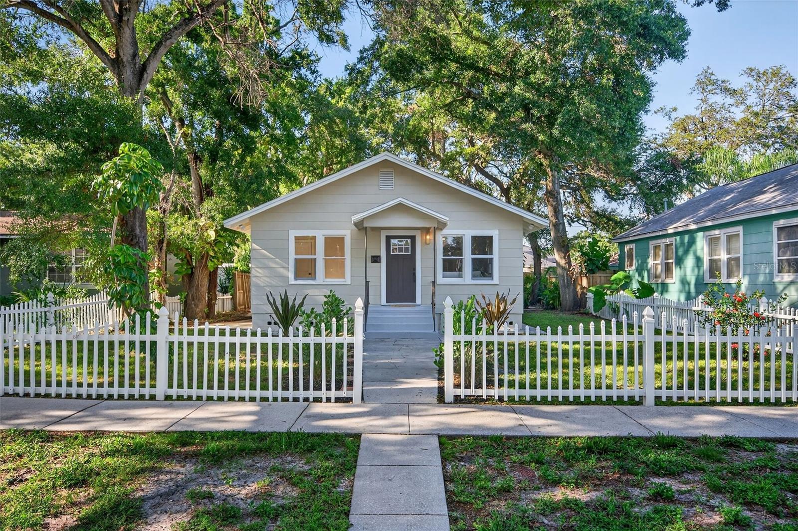 "Bungalow Dreams in Kenwood." - Sometimes the dreamiest bungalows hold the best surprises; and this 1949 Kenwood stunner is no exception. Completely reimagined and thoughtfully updated, this home blends timeless character with all the modern conveniences today’s city dweller craves. Step inside to a sun-filled open floor plan that flows from the living room to the dining area and into the spectacular chef-inspired kitchen. Designed with a warm, organic sensibility, the space balances natural wood and calming muted green cabinetry, anchored by a spacious center island with seating, abundant counter space, and storage; perfect for entertaining or everyday living. A convenient laundry closet is located off the kitchen and dining room. The desirable split-bedroom layout offers 3 bedrooms and 3 full bathrooms for privacy and function. At the front of the home, two guest bedrooms share a large hallway bath with extra storage. Tucked away off the kitchen, the primary suite creates a serene retreat with dual closets, an oversized bedroom, and a spa-like bath that continues the home’s organic design vibe. A versatile bonus room with an en suite bathroom holds the best surprise; ideal as a home office, yoga or meditation space, or an additional guest area. Sliding doors off the kitchen lead to a private courtyard-style backyard with a paver patio and lush landscaping, offering a perfect spot for morning coffee or evening gatherings under the stars. Nestled in Historic Kenwood, this home offers the best of both worlds. Just minutes from the vibrant energy of Downtown St. Pete and the sandy beaches of the Gulf. This is more than a bungalow, it’s a lifestyle. Located in flood zone X.