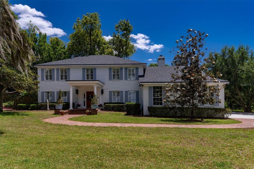 An incredible opportunity in one of Maitland’s exclusive communities offers stunning lakefront views of Lake Catherine and Lake Eulalia. With one of only three private docks on Lake Catherine, this is a rare and special property. A charming brick street winds along the lake and leads to this timeless residence, uniquely positioned with frontage on two lakes. This elegant two-story home features five bedrooms and sits on nearly two acres, providing exceptional privacy. Surrounded by indigenous Florida plants and abundant wildlife, the natural setting becomes part of your everyday lifestyle, making you feel like you are living in the countryside. A gorgeous solid wood Dutch door welcomes you into a gracious foyer with soaring ceilings and expansive windows that fill the home with natural light. Authentic oak floors extend throughout most of the home, complemented by custom detailed millwork throughout. Substantial crown molding in every room of the home draws the eye upward, adding depth and a polished, high-end finish to the interior. The layout includes a formal living, dining and great room along with a downstairs office or optional fifth bedroom for guests. A bright Florida room spans the back of the home and opens to outdoor living spaces and a new fire pit, perfect for entertaining. Custom built-ins and cabinetry, thoughtfully designed and crafted by Busby Cabinetry, enhance both beauty and functionality throughout this exceptional home. The kitchen opens seamlessly to the great room and features 42-inch cabinetry, a center island, high-end Thermador stainless steel appliances and exotic granite countertops. A breakfast room and additional peninsula provide ample space for casual dining and entertaining. The great room overlooks Lake Eulalia, while the living room and bedrooms capture serene views of Lake Catherine, both offering picturesque sunsets. Upstairs, the spacious primary suite includes an en-suite bath with dual sinks, a vanity area, a soaking tub and a walk-in shower. Additional bedrooms are generously sized and feature large closets. The light-filled Florida room connects to a bricked, covered porch with stately columns, creating an inviting indoor-outdoor flow. The backyard is framed by mature landscaping and shaded by a canopy of trees, offering a peaceful, secluded lakeside retreat. Recent improvements include a new roof (2023), new siding (2021), an updated dock, new garage doors and New Orleans-style lanterns. Additional upgrades include a new front Dutch door, spray foam energy-efficient insulation, walk-in closets in all bedrooms and an indoor laundry room. The three-car garage includes an EV charger, with one bay currently converted into a climate-controlled gym featuring rubber flooring and mirrors. The home is also equipped with two Rinnai tankless water heaters, wood plantation shutters, custom millwork, crown molding, wainscoting and chair rails throughout. Enjoy a short walk to downtown Maitland’s events, Lake Lily, the popular Sunday Farmer’s Market, the Enzian Theater and a variety of excellent restaurants. The brand new Maitland Library is being built around the corner. Watch Lake Lily fireworks from your private dock and benefit from easy access to I-4, Winter Park Village, and Park Avenue, all just minutes away.
