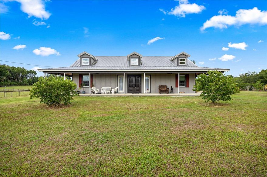 Bring your horses, cows, goats, and chickens to this stunning 10.44-acre agricultural estate featuring fenced pastures, barns, workshops, and endless possibilities. This beautifully crafted 3-bedroom, 2-bath custom farmhouse offers 3,471 total SF with vaulted ceilings, luxury finishes, wrap-around porches, and an open-concept design perfect for entertaining. The chef’s kitchen features granite countertops, stainless appliances, gas cooktop, oversized island, custom wood cabinetry, pantry, and built-in appliance garages. The spacious primary suite includes dual walk-in closets and a spa-style bath with oversized slate shower, rain head, jets, and dual vanities. Additional highlights include luxury wood-look tile flooring, solid-core doors, extensive crown molding, mudroom/laundry with dog wash station, fully furnished interior, and a galvanized metal roof.

The property is fully equipped for country living with four fenced pastures, livestock chutes, chicken coops, multiple barns, workshops, storage buildings, pole barns, irrigation, fruit trees, mature oaks, bamboo groves, and room for up to 5 homes on this family-zoned agricultural parcel. Located near Lake Weir, Ocala National Forest, The Villages, and the World Equestrian Center, this one-of-a-kind property offers peaceful country living with convenient access to shopping, dining, boating, golfing, and outdoor recreation.