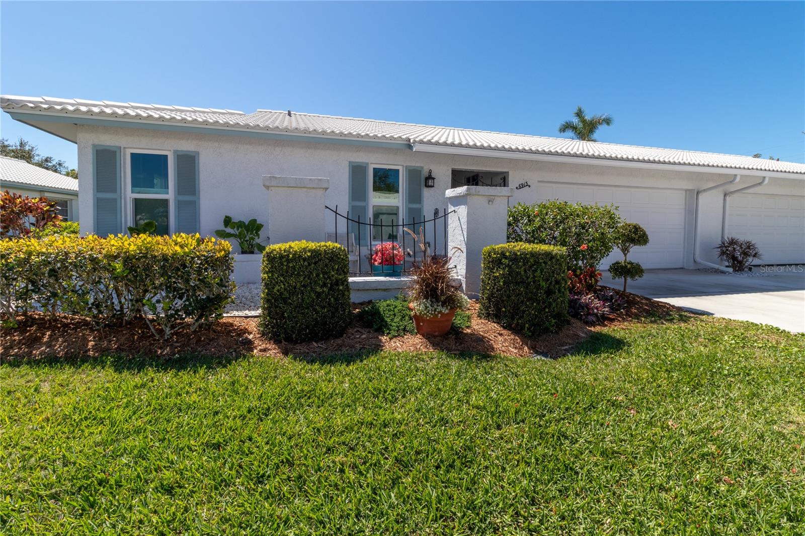 One or more photo(s) has been virtually staged. Welcome to your dream 55+ community in charming West Bradenton! This beautifully maintained condo, nestled on a quiet cul-de-sac in the sought-after Village Green community, offers the perfect blend of comfort, convenience, and peace of mind. Built in one of the most desirable high-and-safe locations. Securely located in Flood Zone X and Evacuation Zone E. With over 1900 sq. ft. of versatile living space, this home features 2 spacious bedrooms, 2 updated bathrooms, and a large galley-style kitchen with new quartz countertops, striking herringbone backsplash, and classic mid-century modern cabinetry. Expansive living areas include bright living/dining room, cozy family room, and a sun-filled Florida room. A roomy 2-car garage with built-in cabinets and shelving, perfect for storage or workspace. Recent updates make this home truly move-in ready with luxury vinyl flooring, nearly all-new windows, refreshed bathrooms, and exterior upgrades including new driveway and charming paver walkway and patio. Step outside and you’re moments from the sparkling community pool, perfect for relaxing or socializing. The location can’t be beat – minutes from Anna Maria Island’s beaches, excellent medical facilities, shopping, dining, and outdoor escapes like Robinson Preserve, Palma Sola Botanical Park, and DeSoto Park. This home is ideal for both relaxation and entertaining, offering a lifestyle that’s as practical as it is enjoyable. Don’t just dream about Florida living—make it your reality!