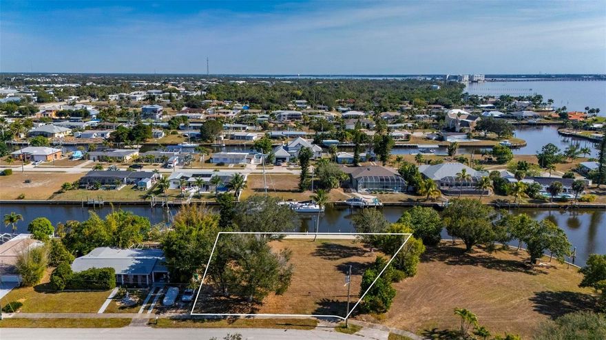 This exceptional .34-acre vacant waterfront lot offers direct sailboat access to the Gulf of Mexico with no bridges, and is ideally located just minutes by boat from the new Sunseeker Resort and downtown Punta Gorda. Directly across from Charlotte County’s Severin Park, the property enjoys a peaceful setting with attractive green space views. The lot measures approximately 95 feet across the front, 138 feet on the right side, 125 feet on the left, and offers 138 feet of waterfront. Extensive improvements have already been completed, including a new seawall cap, hydro-static pressure jet filters, and polyurethane-sealed seams installed by Florida Seawall Solutions in 2022. In 2023, a 97' x 8' marginal dock was constructed along the seawall, with all pilings wrapped in vinyl and cut 60 inches above deck height. The dock features Owens Corning “Barefoot Sands” composite decking, which stays cool even in high temperatures, along with two outer mooring poles. A fully loaded 16,000-lb Deco Concept CRS remote-operated boat lift was also installed, supported by four additional vinyl-wrapped lift pilings. Electric and water service run to the dock and include active 50-amp, 30-amp, and 110-volt outlets, as well as a waterline with backflow preventer. All sewer and water charges are current and paid monthly, allowing the future owner to avoid impact hookup fees when building. With its prime location, high-end improvements, and true sailboat access, this lot is an ideal site for your custom Gulf-access dream home.