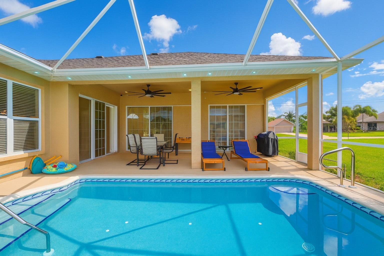 This extraordinary SW Cape Gulf Access pool home offers the perfect blend of modern coastal luxury and investment opportunity, showcasing a new roof (2023), assumable solar panels installed in 2024 for a low monthly light bill, a brand-new high-efficiency A/C system with ultraviolet cell to kill bacteria (2024), and a completely renovated saltwater pool with heater. Designed with soaring ceilings and natural light that accent every finish, the open concept layout is enhanced by large format porcelain tile throughout and a brand-new European-inspired kitchen with an oversized waterfall island, floor-to-ceiling soft-close cabinets, induction cooktop with pop-up ventilation, wall oven, cappuccino maker, drawer microwave, a massive 48” side-by-side refrigerator and freezer, and a custom wine cabinet. The family room is anchored by a granite feature wall with electric fireplace and TV, while pocket sliding doors create seamless indoor-outdoor living to the extended lanai featuring a wood slat accent wall, granite detail, and built-in TV—perfect for entertaining or dining alfresco. The spacious primary suite is a tranquil escape with Euro-spa inspired ensuite boasting frameless glass shower with dual rain heads, full body jets, towel warmer, floating dual vanities, smart mirror, built-in Bluetooth speakers, and a custom-designed walk-in closet. Two additional large guest bedrooms with closet organizers and private full baths are located on the opposite side for privacy. Outdoors, enjoy the heated pool, relax on your dock, fish, or take your boat out for a Gulf-access cruise in just 30 minutes from your backyard. Beyond being a dream home, this property also doubles as a savvy investment: it is currently rented on Airbnb until March 2026 with transferable reservations, giving investors immediate income potential, or it can be purchased as a spectacular family home for personal enjoyment. Every upgrade, from the luxury finishes to the energy-efficient systems, makes this waterfront property one of the finest offerings in Cape Coral.