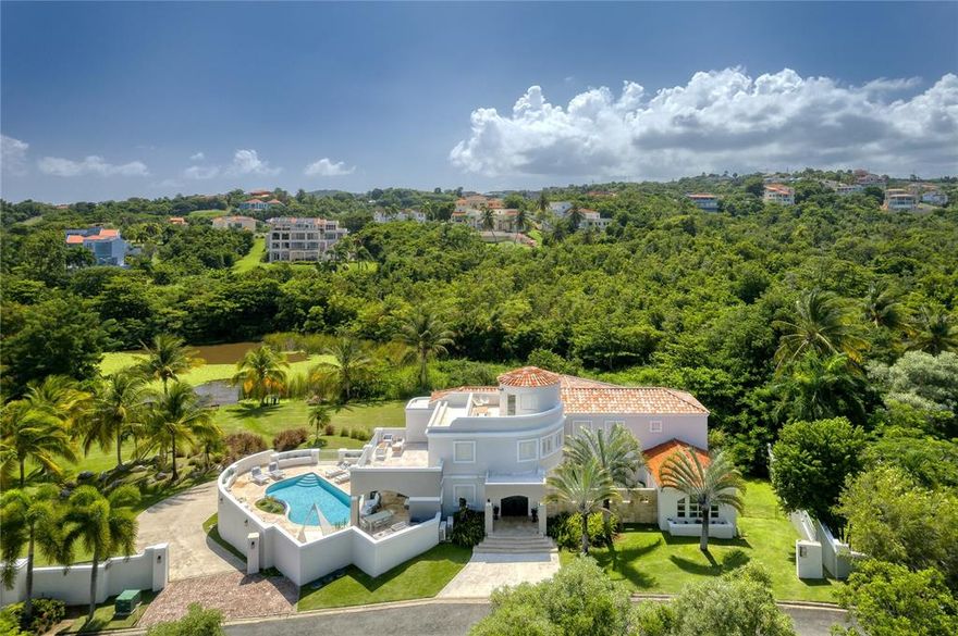 Majestically located atop the picturesque hillside of Palmas del Mar, this inviting 3-level residence features panoramic views of the marina and adjacent lake. Affording over a quarter of an acre of tastefully manicured land, the Mediterranean Contemporary inspired estate offers an exceptionally privileged location with unmatched privacy.

The second floor serves as the main entertaining area, showcasing an ensuite guest bedroom, living room, gourmet kitchen with breakfast nook and office, in addition to a family room which connects to a sizable covered terrace with pool.

The third level is composed of four bedrooms and three bathrooms. The master suite is accented by a spacious balcony overlooking the pool and scenic landscape. A rooftop terrace serves as one of the property's many highlights.

The ground floor houses a 3-car garage and recreation room with golf simulator, as well as an additional sitting room, office, storage, two bathrooms and laundry. A  full-power generator is also generously provided.

Offering the ultimate levels of comfort and convenience, Palmas del Mar is internationally renowned for its top golf courses, tennis courts, equestrian center, private school, restaurants, shopping venues and beachfront location on the southeast coast of the island. Only a 40-minute drive away from San Juan, enjoy the pinnacle of resort living while still being in close proximity to the Metropolitan area.

Annual HOA: $1,200
