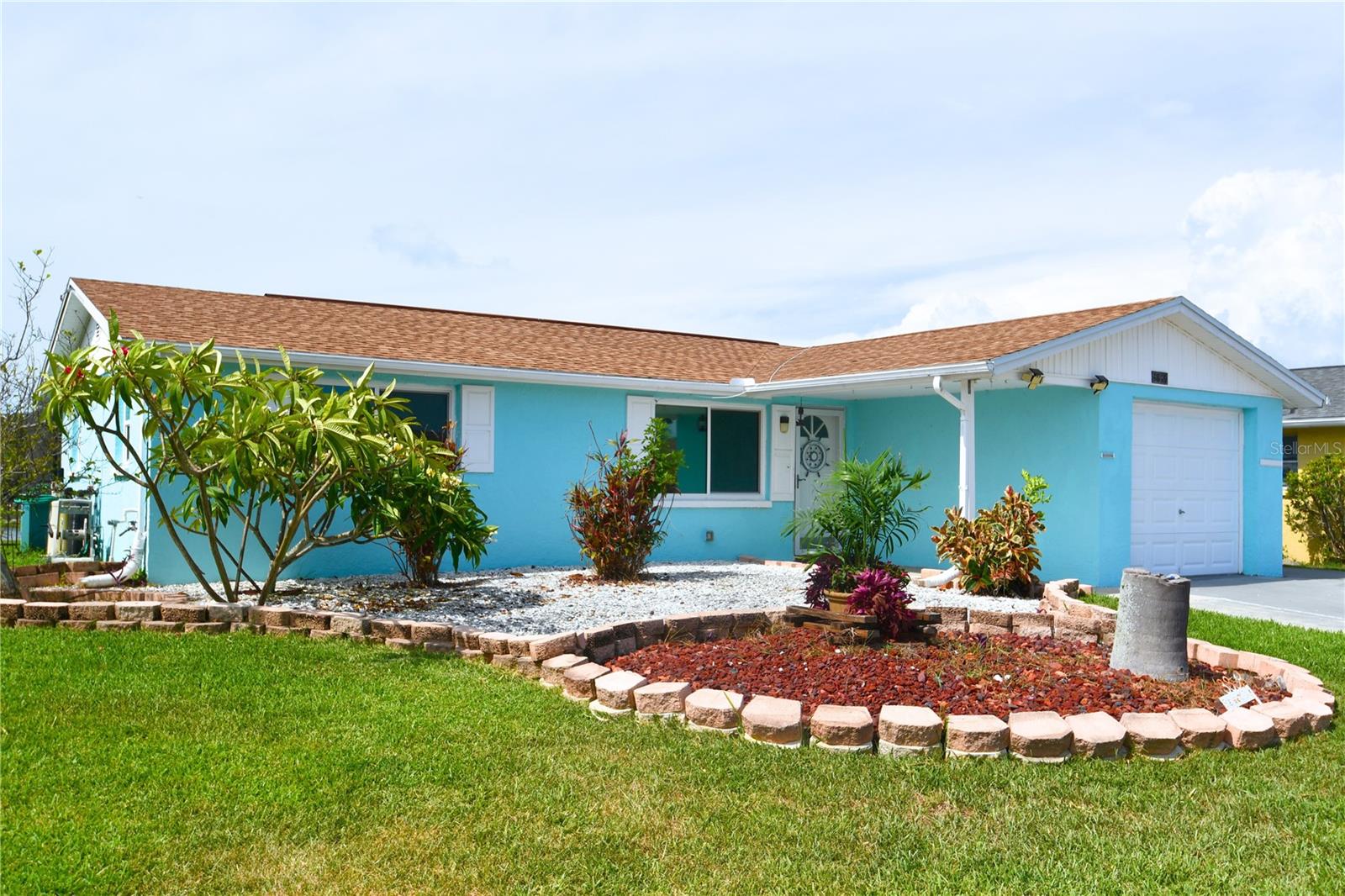 Welcome to Paradise: Upgraded Waterfront Living at Its Finest Discover the perfect blend of comfort, style, and Florida charm in this beautifully updated 2-bedroom, 2-bath waterfront home, tucked away on a peaceful cul-de-sac. Whether you’re looking for a serene full-time residence or the ultimate seasonal retreat, this property is a rare gem—thoughtfully upgraded and meticulously maintained by its current owner. From the moment you arrive, the mature landscaping and lush greenery, nourished by an irrigation system fed by the freshwater canal, set the tone for what’s to come. Step inside and you’ll be greeted by a calming neutral palette and elegant wood-look ceramic tile flooring that flows throughout the main living areas. The spacious open-concept living and dining room is designed to impress, with oversized picture windows that invite natural light and showcase stunning views of the screened lanai and glistening canal. It’s the perfect setting to unwind, entertain, or simply enjoy the ever-changing beauty of the water. (No flooding from recent hurricanes) The chef’s kitchen is a showstopper—bright, spacious, and functional. Enjoy a large eat-in area perfect for casual meals or morning coffee with a view. Recent upgrades include marble-inspired quartz countertops and backsplash, sleek stainless steel appliances (including a Whirlpool French door fridge and Samsung 5-burner electric range), and a custom island with an undermount sink and dishwasher. A cozy breakfast bar adds additional seating and charm. The primary bedroom is a peaceful retreat, measuring 11' x 14', with soft carpeting and a built-in closet. The second bedroom is equally comfortable, making it ideal for guests or a home office. Both bathrooms have been completely remodeled with luxury in mind—featuring custom tilework, walk-in showers, modern vanities, stainless fixtures, and designer lighting. Step outside to your private paradise: a sprawling 22' x 30' screened lanai with a self-watering raised garden bed—perfect for entertaining or relaxing in total comfort thanks to mosquito screening. Function meets form in the upgraded garage, complete with Samsung front-load washer and dryer, insulated attic with cooling fan, and plenty of storage. The yard is a gardener’s dream, featuring mature plantings, a fruit-bearing Meyer lemon tree, and vibrant Plumeria. You’ll also enjoy a full suite of landscaping equipment, including a riding lawn mower, push mower, and an array of trimming tools. Ideally located close to everything—shopping, dining, hospitals, and just minutes from the Tarpon Springs sponge docks, scenic beaches, and local parks—this home offers not just a place to live, but a lifestyle to fall in love with. With almost 100K in upgrades over the last few years, this is more than a home—it's your waterfront sanctuary. Come experience it for yourself:)