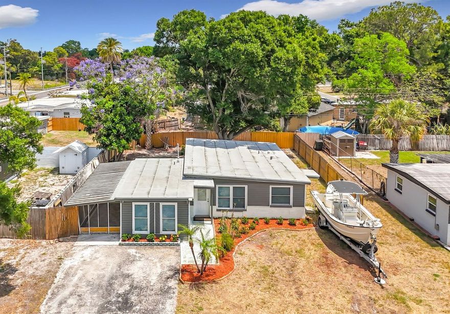 Completely renovated block home offering 4 bedrooms and 2.5 baths, ready for immediate move-in. NEW ROOF (2026) and hot water heater (2026), plus an extended double driveway with ample space for cars, RVs, or boats. NO FLOOD ZONE, NO HOA, NO CDD!  Inside, enjoy a bright, open floor plan featuring new paint, luxury vinyl flooring, LED lighting, and hurricane impact-rated windows. The beautifully updated kitchen showcases QUARTZ countertops, new cabinetry, a custom backsplash, and stainless steel appliances.  The primary suite includes a walk-in shower with custom tile and glass enclosure, along with a dual-sink vanity topped with granite. Bedrooms two and three are spacious and filled with natural light. The fourth bedroom offers added flexibility with its own private water closet, complete with a new vanity and granite countertop.  The hall bathroom has been fully renovated with a new tub and shower featuring a built-in niche, updated vanity, and custom tile work. In addition, an interior laundry room adds convenience.  Step outside to a fenced backyard and a versatile screened-in patio that is ideal for entertaining, pets, or relaxing year-round. The patio also includes a separate storage room, perfect for additional storage or a workshop.  With its flexible layout, this home is ideal for multi-generational living, growing families, or generating rental income. Whether you're looking for a primary residence or an investment opportunity, this lovely home is ready to meet your needs. Schedule your private showing today!
