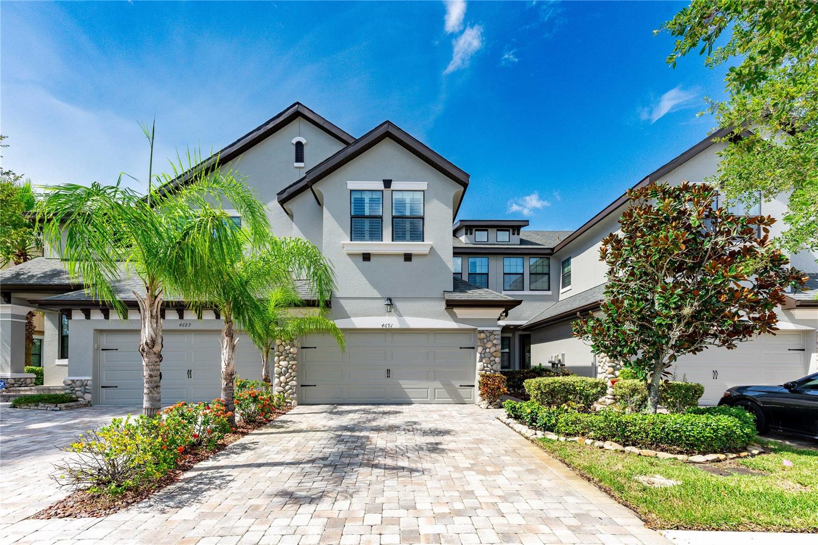 Welcome to a beautifully appointed townhome in the highly sought-after Seven Oaks Community of Maple Glen — where elegance meets everyday comfort. This former model home lives like a single-family home, offering 3 spacious bedrooms, 2.5 bathrooms, and a two-car garage, ideal for families of all sizes. Step into the light-filled, open-concept living area with the beautiful chef-inspired kitchen featuring double ovens, a brand-new microwave, and a stunning center island — perfect for both entertaining and everyday meals. The spacious family room boasts surround sound and an array of upgrades, including crown molding, ceramic tile, wood flooring on the stairs and upper level, plantation shutters, granite countertops, and custom window treatments. Savor your morning coffee in the cozy breakfast nook or relax on the covered lanai, featuring a stunning view, built-in speakers, and tranquil water scenery. The professionally landscaped backyard offers a peaceful retreat for gatherings or quiet evenings under the stars. Upstairs, the spacious primary suite boasts two custom walk-in closets and a luxurious en-suite bath with a garden tub and dual vanities. Two additional bedrooms and a full bath provide ample space for family or guests each with custom closets. The upstairs landing features a built-in desk, making it an ideal space for a home office or a dedicated area for homework. Additional highlights include an upgraded washer and dryer, two ceiling-mounted storage racks, and a walk-in storage room in the garage. Perfectly positioned near Wiregrass shops, Tampa Premium Outlets, and top-rated dining, this home offers unmatched convenience. Just steps from BayCare Hospital and minutes from Advent Health, with easy access to major highways (I-75, SR 56 and SR 54) and top-rated schools — it’s the ideal blend of luxury and location. This pristine, move-in-ready townhome is a rare find. Don’t miss your opportunity to call it home!