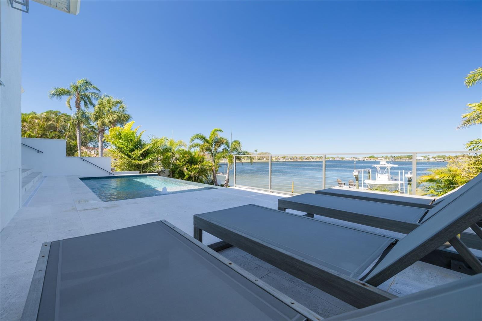 Exquisite Waterfront Oasis on Smacks Bayou! Indulge in the pinnacle of Florida waterfront living with this breathtaking estate, offering expansive, unobstructed views of Smacks Bayou. Built in 2022 with elevated construction, this home provides peace of mind, having remained untouched by storms while embracing the beauty of coastal living. Spanning approximately 3,094 square feet, this architectural masterpiece boasts 3 spacious bedrooms, 3 full bathrooms, and 1 half bath, all meticulously designed to blend modern elegance with timeless Moroccan-inspired details. A six-car garage, equipped with five mini-splits and two car lifts, ensures ample space for your prized collection. Effortless luxury begins the moment you arrive. Park in your expansive garage and take the private elevator directly to the main level—an unparalleled convenience for groceries, packages, and daily living. The chef’s kitchen is a culinary dream, featuring top-of-the-line JennAir appliances, including a six-burner gas range, built-in refrigerator and dishwasher, and an exquisite waterfall island adorned with marble countertops. The interiors exude warmth and sophistication, with hand-selected fixtures from Anthropologie, 8-foot solid core doors, and a seamless open-concept floor plan that showcases panoramic waterfront views from the moment you enter. The primary suite is a sanctuary, complete with a spa-like bath featuring a curbless shower, Moroccan-inspired Zellige Clay Tile walls, and a luxurious soaking tub beneath a cascading rain shower head. Custom Arhaus pendant lighting adorns the bedside, while a sprawling walk-in closet with a built-in island offers space for every wardrobe essential. Each guest ensuite is a private retreat, featuring marble tile, marble countertops, and meticulous craftsmanship. The home’s seamless indoor-outdoor flow is enhanced by Origin bifold doors, allowing you to transition effortlessly to the covered terrace. Here, you’ll find a Sekas custom infinity pool, a natural gas firepit and grill, and a fully equipped outdoor kitchen with an ice maker, sink, and refrigerator—perfect for entertaining against a stunning waterfront backdrop. The newly constructed seawall and composite dock are designed for effortless boating, featuring a 10,000 lb boat lift. Immerse yourself in serene waterfront living, from watching dolphins glide through the bayou to setting sail from your private dock. Located just minutes from Downtown St. Petersburg, the Vinoy Golf Club, world-class shopping, museums, and fine dining, this residence is more than a home—it’s an invitation to an unparalleled lifestyle. Don’t miss the opportunity to own this waterfront masterpiece. Call today to experience its grandeur firsthand! **Metal Roof** Impact Windows and Doors** Whole Home Generator** Elevated Construction**