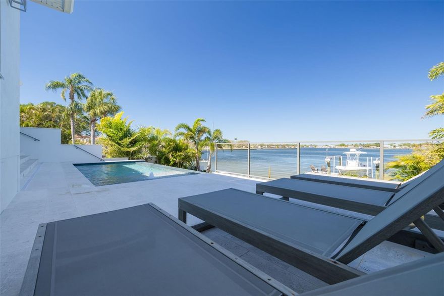 Exquisite Waterfront Oasis on Smacks Bayou!  Indulge in the pinnacle of Florida waterfront living with this breathtaking estate, offering expansive, unobstructed views of Smacks Bayou. Built in 2022 with elevated construction, this home provides peace of mind, having remained untouched by storms while embracing the beauty of coastal living.  Spanning approximately 3,094 square feet, this architectural masterpiece boasts 3 spacious bedrooms, 3 full bathrooms, and 1 half bath, all meticulously designed to blend modern elegance with timeless Moroccan-inspired details. A six-car garage, equipped with five mini-splits and two car lifts, ensures ample space for your prized collection.  Effortless luxury begins the moment you arrive. Park in your expansive garage and take the private elevator directly to the main level—an unparalleled convenience for groceries, packages, and daily living. The chef’s kitchen is a culinary dream, featuring top-of-the-line JennAir appliances, including a six-burner gas range, built-in refrigerator and dishwasher, and an exquisite waterfall island adorned with marble countertops.  The interiors exude warmth and sophistication, with hand-selected fixtures from Anthropologie, 8-foot solid core doors, and a seamless open-concept floor plan that showcases panoramic waterfront views from the moment you enter. The primary suite is a sanctuary, complete with a spa-like bath featuring a curbless shower, Moroccan-inspired Zellige Clay Tile walls, and a luxurious soaking tub beneath a cascading rain shower head. Custom Arhaus pendant lighting adorns the bedside, while a sprawling walk-in closet with a built-in island offers space for every wardrobe essential.  Each guest ensuite is a private retreat, featuring marble tile, marble countertops, and meticulous craftsmanship. The home’s seamless indoor-outdoor flow is enhanced by Origin bifold doors, allowing you to transition effortlessly to the covered terrace. Here, you’ll find a Sekas custom infinity pool, a natural gas firepit and grill, and a fully equipped outdoor kitchen with an ice maker, sink, and refrigerator—perfect for entertaining against a stunning waterfront backdrop. The newly constructed seawall and composite dock are designed for effortless boating, featuring a 10,000 lb boat lift. Immerse yourself in serene waterfront living, from watching dolphins glide through the bayou to setting sail from your private dock.  Located just minutes from Downtown St. Petersburg, the Vinoy Golf Club, world-class shopping, museums, and fine dining, this residence is more than a home—it’s an invitation to an unparalleled lifestyle.  Don’t miss the opportunity to own this waterfront masterpiece. Call today to experience its grandeur firsthand!  **Metal Roof** Impact Windows and Doors** Whole Home Generator** Elevated Construction**