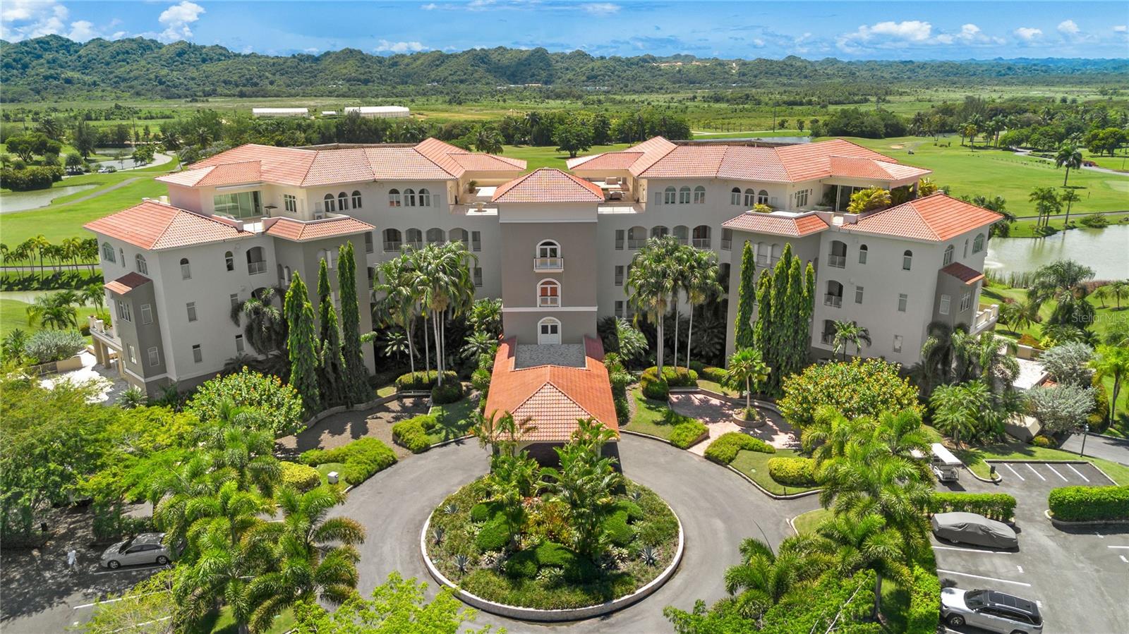 Nestled within the prestigious Ritz Carlton Reserve at Dorado Beach, a world renowned five-star resort, this exquisite ground floor 3 bedroom, 2-and-a-half-bathroom luxury condo in Plantation Village II offers a seamless blend of sophistication and tropical elegance. With panoramic views of the resort’s award-winning golf courses from your own infinity pool, this fully furnished 2,719 square foot Ferrer model residence promises an unmatched lifestyle.
Step inside to discover an expansive open concept living and dining area that reflects the vibrant hues of the Caribbean, creating a warm and inviting atmosphere. The spacious living room flows seamlessly into a gourmet kitchen, featuring high-end Kitchen Aid appliances, custom white lacquer cabinetry, and gleaming granite countertops. Stunning glass tile backsplashes add a touch of artistry, while the kitchen island serves as both a culinary workspace and an inviting gathering space, perfect for entertaining friends and family.
Throw open the doors to your sprawling, meticulously designed terrace. The outdoor kitchen features specialized PVC lacquered weatherproof cabinetry, fully integrated Nexgrill gas grill and a TV to creating the ideal setting for alfresco gatherings. The bespoke 20 by 14-foot saltwater, temperature-controlled pool features mosaic hand tiling throughout. A serene retreat, surrounded by chic loungers, lush tropical landscaping, large industrial outdoor AC units, and fully extending electric awnings, ensures a perfect space for relaxation and entertaining day or night.
This well-appointed condo is designed as a tranquil retreat with closets outfitted by local woodworkers providing ample storage and versatility. The primary suite boasts a spa-worthy en-suite bathroom, complete with a double vanity, soaking tub, stone wall shower, and tranquil views of the green landscape surrounding it.
Additionally, the condo features a private laundry area equipped with a top-of-the-line washer and dryer for your convenience. The purchase includes a camera alarm system with 6 cameras and an industrial safe, your security is always guaranteed. In addition, this exceptional residence comes with rare-to-market, enclosed, climate-controlled garage and includes a lux Onward golf cart. Use it to explore the sprawling resort grounds and pristine beaches with ease.
Residence 107 truly embodies the ultimate tropical lifestyle, where every detail has been meticulously curated for comfort and elegance, inviting you to indulge in the beauty and amenities of Dorado Beach, Puerto Rico.