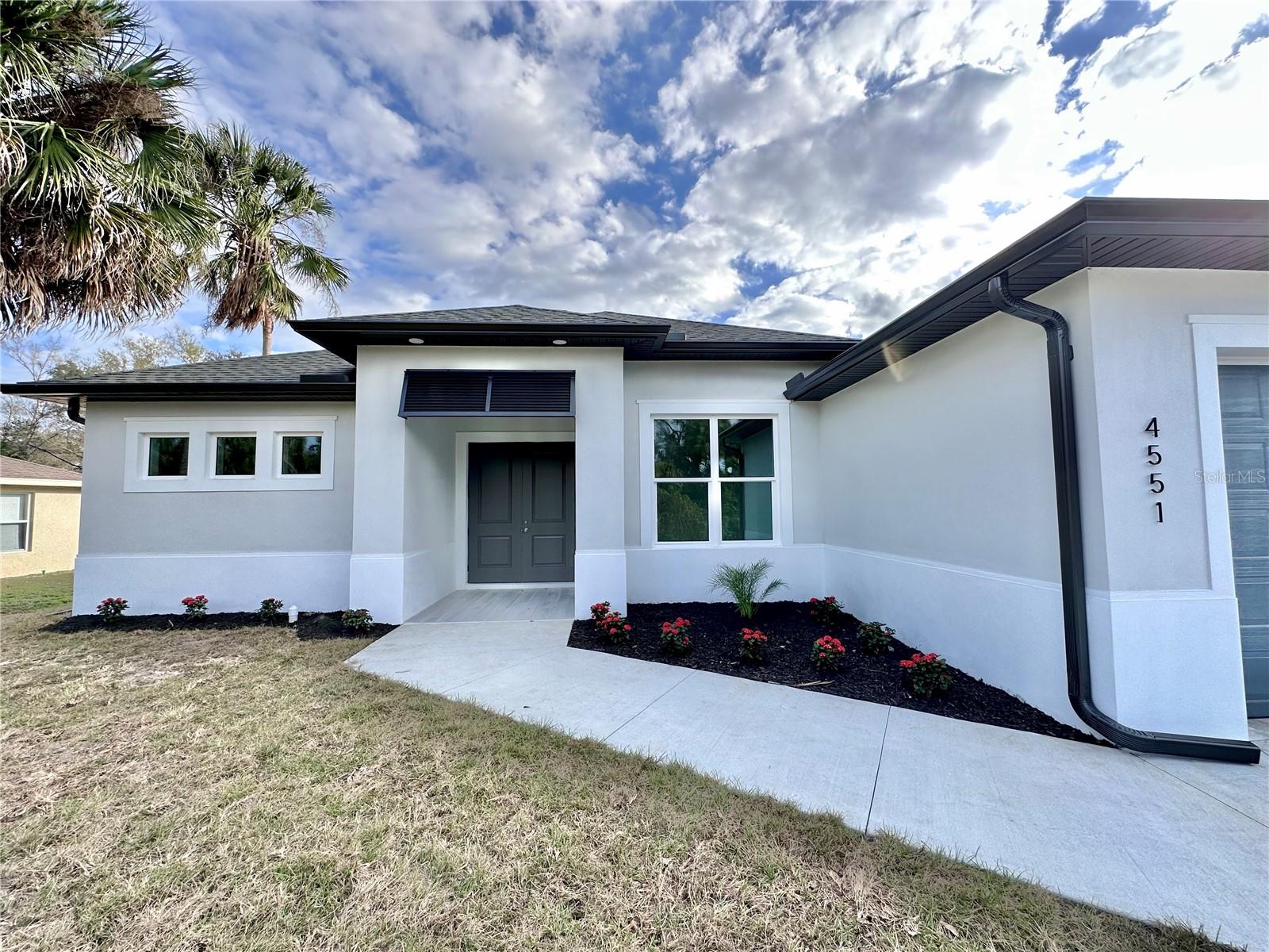LOCATION IS KEY! Welcome to the luxury living in this meticulously crafted 2024 custom home, now complete and ready for your move-in! Boasting over 2,640 square feet of total space, this residence embraces an open-concept floor plan featuring 3 bedrooms alongside a versatile den/office room, 2 bathrooms, and a 2-car garage, all seamlessly integrated with a beautiful, spacious porch. No detail has been spared in the pursuit of excellence, with upgrades galore: oversized driveway, impact windows and doors, an inviting electric fireplace, and the allure of luxury vinyl flooring throughout. The kitchen is a chef's dream, equipped with soft-close cabinets crowned with quartz countertops, professional-grade appliances, accented by contemporary light fixtures and recessed lighting in key areas. Light, and airy color combination throughout, infusing the home with an atmosphere of effortless elegance and tranquility. Soaring high ceilings, accentuated by a tray ceiling in the master bedroom, while ceiling fans provide gentle breezes in every room. A spacious inside laundry room, complete with wall cabinets, adds convenience to daily living. 8' interior doors, and tall baseboards frame the home with sophistication, while the master suite indulges with two walk-in closets, a double vanity, and a beautiful walk-in shower. Open the three-panel slider in the living room or the double-panel slider from the master bedroom to unveil the sprawling 27 feet covered porch/lanai, overlooking the large backyard, inviting gatherings and moments under the open sky. The large backyard offering plenty of room for future addition of a pool, where endless days of relaxation and enjoyment await. Nestled in the desirable location of North Port, with easy access to I-75 for convenient commuting to Fort Myers and Sarasota areas. Schools, shopping destinations, and dining establishments within easy reach, every convenience is at your doorstep. Explore the excitement of the new Downtown Wellen Park, where culture, entertainment, and leisure converge to create unforgettable experiences. Discover the world-famous Mineral Springs, known for their therapeutic properties, offering moments of rejuvenation and relaxation. North Port's Water Park invites you to immerse yourself in a world of endless summer fun and unforgettable thrilling adventures. Don't miss your chance to experience the pinnacle of luxury living—schedule your private showing today and make this dream home yours!