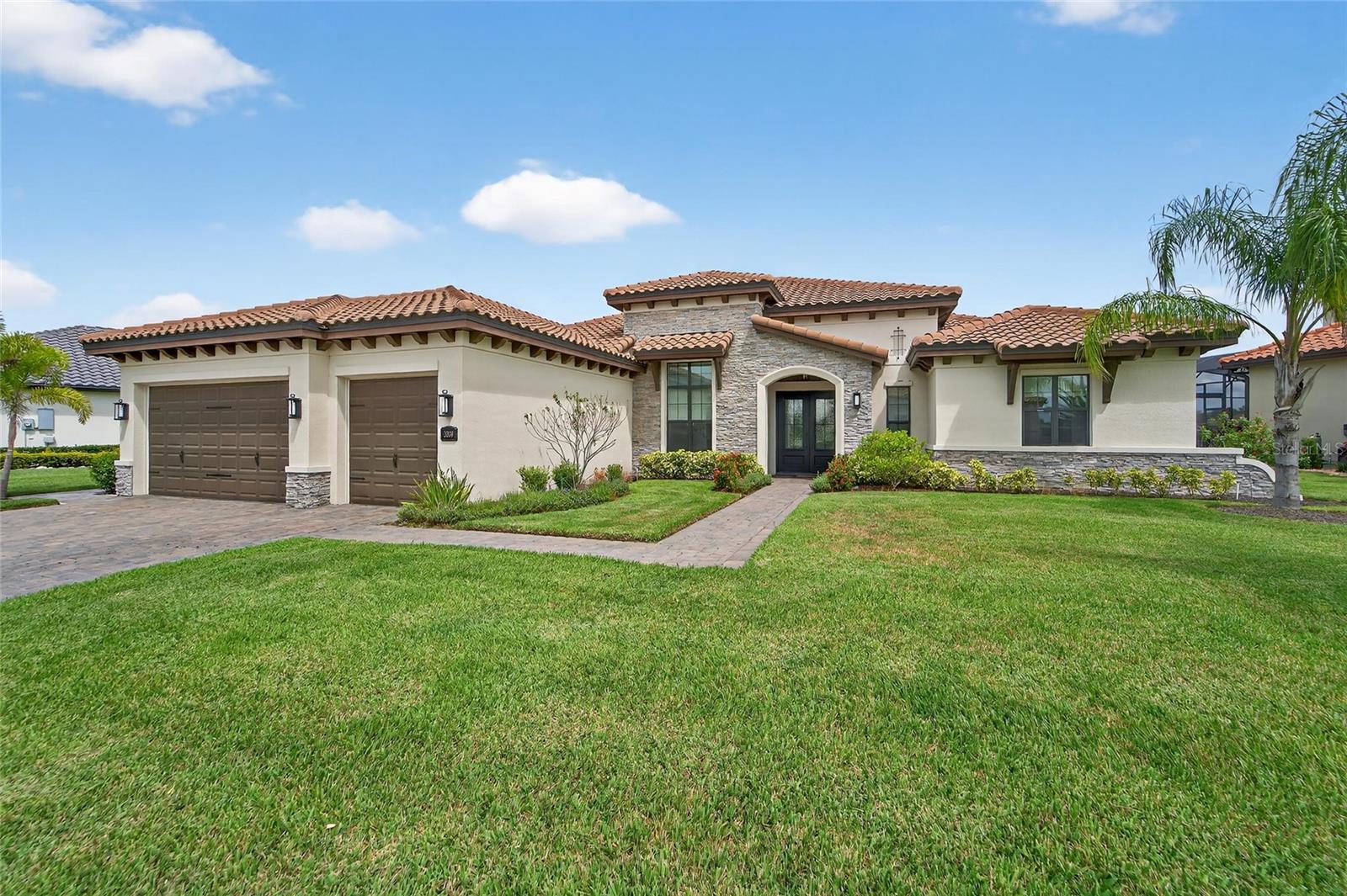 Discover a truly stunning Arthur Rutenberg home in the esteemed Sanctuary neighborhood of Grasslands Golf & Country Club. Designed for modern living, this residence showcases a sophisticated, contemporary style with an open concept and an exceptional 3-way split floor plan that ensures privacy for all. Enjoy expansive light-filled spaces, grand double entry doors, and seamless indoor-outdoor living with dramatic sliding glass doors that frame peaceful pond views and breathtaking Florida sunrises and sunsets. The open great room is enhanced by soaring ceilings and elegant crown molding, flowing easily to a spacious screened lanai. This inviting outdoor retreat features a summer kitchen, plenty of covered space for dining and relaxation, an electric fireplace, panoramic vistas and plenty of room for a pool. Large chef’s kitchen with solid wood cabinetry, granite countertops, center island, hidden pantry, breakfast bar, and a dedicated coffee station. Flexible dining spaces and a generous open layout designed for effortless entertaining or comfortable family gatherings. Best of all Three-way split plan offers privacy: Luxurious primary suite with pond views, spa bath, dual walk-in closets, and a spacious walk-in shower. Two bedrooms with a shared full bath, ideal for family or guests. Third private guest suite with its own en suite bath, perfect for visitors or multi-generational living. There are impressive upgrades throughout this home: Gorgeous wood plank tile throughout living areas, Interior laundry with custom cabinetry and sink, Tankless hot water system, Dual-zone A/C, Oversized climate-controlled 3-car garage (third one for a golf cart) with epoxy floors. Enjoy 24-hour guard-gated entrance, and premier privacy—all within Grasslands’ prestigious community. Location Perks include: Minutes from Lakeside Village shopping, top restaurants, entertainment, and medical facilities. Optional Grasslands Golf & Country Club membership available. Enjoy a contemporary, open, and effortlessly stylish home—best-in-class for those seeking privacy, elegance, and premier country club living in Lakeland’s Grasslands. This is sanctuary reimagined, move-in ready, and simply exceptional.