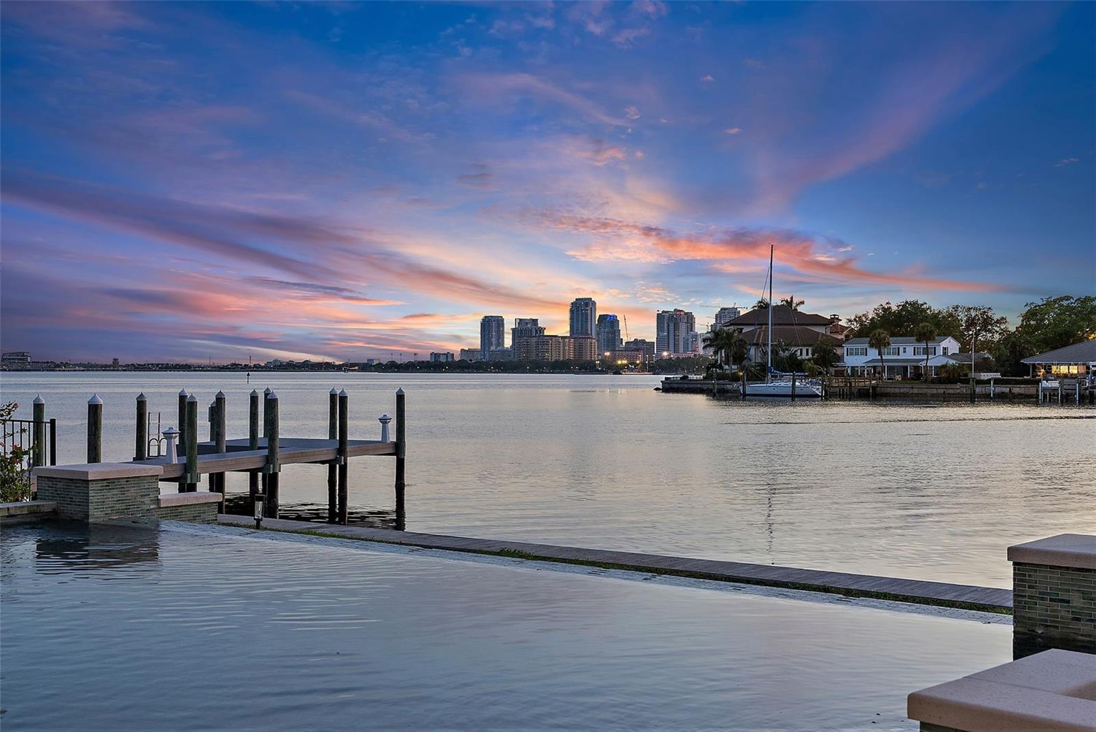 This waterfront showstopper on Tampa Bay is pure luxury, featuring ocean views from almost every room. Built by Windstar and extensively remodeled to perfection with no cost spared in recent years, is sure to impress. Located on an exclusive island in Snell Isle with only 30 other houses, this stunning residence is nestled along the serene waterfront of St. Petersburg. It offers breathtaking views of the downtown skyline and Tampa Bay, boasting an impressive 132 feet of waterfront living. The home showcases an array of luxurious upgrades implemented in recent times, culminating in an unparalleled living experience. The kitchen is a masterpiece crafted by Brightwood Works, featuring custom rift sewn oak cabinetry meticulously hand-stained to harmonize with Brazilian Calacatta Viola Marble countertops and walls. The island, clad in leathered Taj Mahal stone with waterfall edges, serves as the centerpiece of culinary excellence. The home is adorned with oak floors, complemented by new bathrooms boasting with exquisite stone finishes. The outdoor oasis is equally impressive, featuring, a new seawall, dock, and two boat lifts (24k lbs and 12k lbs), alongside an infinity pool and landscaping that enhances the natural beauty of the waterfront retreat. This home is conveniently located minutes from downtown and Tampa International Airport, and in close proximity to shopping centers including the Northeast Shopping Plaza and Whole Foods, offering effortless access to the best of urban amenities. With its timeless contemporary design, high-quality materials, and unparalleled attention to detail, this waterfront sanctuary promises a lifestyle of refined luxury and unparalleled tranquility, just minutes from the world-renowned beaches of St. Petersburg.