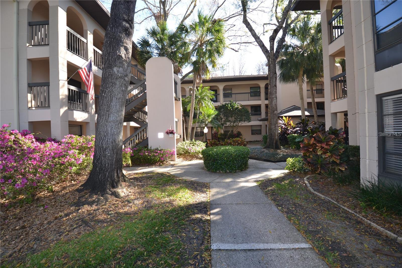 This 1st floor, two bedroom condo within the desirable Ridgemoor subdivision presents a wonderful opportunity for anyone seeking a peaceful and comfortable living experience in a gated community. As you drive into this tranquil enclave, you'll find your own reserved, covered parking space with a convenient storage unit located directly in front. A pleasant stroll through the garden-like setting will bring you to the front door, where you’re welcomed by a storm and screen door that allows refreshing natural air into your home. Step inside to discover a spacious living room bathed in natural light, creating a warm and inviting ambiance. The condo features brand new, water-resistant flooring and fresh paint, offering a modern, low-maintenance environment. The smart layout showcases two generously sized bedrooms, both with easy-to-care-for tile floors, ensuring your home stays cool and comfortable year-round. The Jack and Jill bathroom setup provides excellent convenience and privacy for both your guests and the primary bedroom. The guest room is also spacious, offering flexibility for various uses. The kitchen is both charming and functional. NEW full-size, high-end stackable washer and dryer in the laundry closet, making everyday tasks easier. Step outside onto the screened patio, a true highlight of the home, where you can unwind and take in the tranquil views of lush landscaping. Additional tile flooring in the patio area enhances its appeal, creating a seamless transition from indoor to outdoor living. For pet lovers, the community is pet-friendly, allowing one small pets under 25 lbs. Ridge Moor is a beautifully maintained community, offering amenities such as a community pool, tennis courts, and a car wash area. The inclusion of water, sewer, trash, and basic cable included with the convenience of living here, ensuring that many essential utilities are taken care of without any hassle. Situated near shopping along East Lake Road and within close proximity to great schools, this condo offers a fantastic location and a comfortable, peaceful lifestyle in a well-established neighborhood.