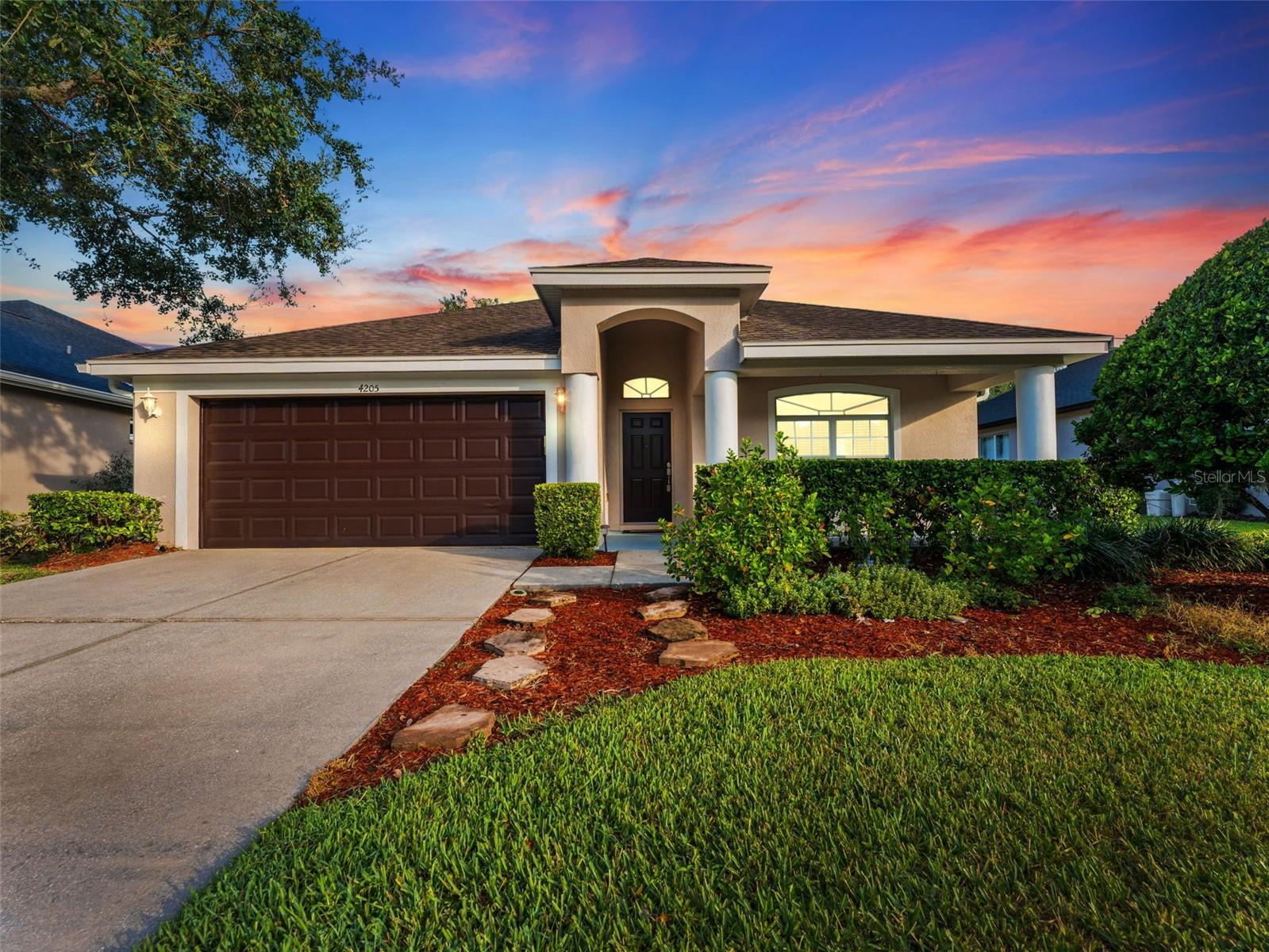 Welcome to your dream home in the highly sought-after gated community of Seven Oaks! This stunning 4-bedroom, 2-bathroom, 2-car garage residence offers the perfect blend of comfort, elegance, and functionality—all on one spacious level. Step inside to discover an open floor plan with soaring ceilings with lots of natural light, and gorgeous hardwood laminate flooring complemented by 6-inch baseboards throughout—no carpet in sight! The formal dining area is perfect for hosting, while the expansive living space flows seamlessly into the oversized kitchen featuring bright white cabinetry, high-end granite countertops, stainless steel appliances, a breakfast bar, and a cozy breakfast nook. The primary suite is a true retreat with tranquil views of the conservation area, and an ensuite bathroom featuring an extra-large soaking tub, walk-in shower, his-and-her vanities, and a custom designer walk-in closet system. Enjoy the convenience of a dedicated indoor laundry room with front-loading washer and dryer included. Relax or entertain outdoors in the spacious screened lanai, complete with beautiful brick pavers and peaceful pond and conservation views. Located in the resort-style community of Seven Oaks, you’ll have access to unparalleled amenities including a Junior Olympic sized lap pool with a double-loop waterslide, a splash park, sun deck, private cabanas, tennis, volleyball, softball, and soccer fields, fully-lit basketball courts, and a state-of-the-art clubhouse featuring a fitness center, locker rooms, showers, a theater with projection screen, and a café. With top-rated schools, Wiregrass Mall, Tampa Premium Outlets, The Grove, and leading hospitals like AdventHealth of Wesley Chapel and BayCare and with quick access to I-75 and SR-56, this location simply can’t be beat. Truly a stunning home! Our online application process is easy and fast, apply today!