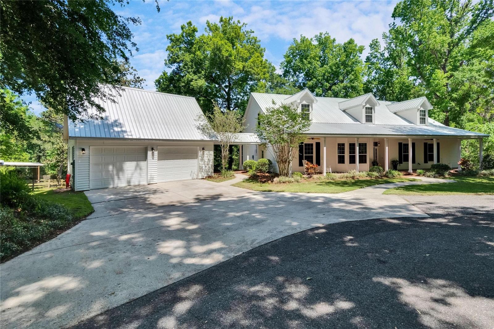 **A Serene Slice of Country Paradise on 5 Acres**
Welcome to your private retreat nestled on 5 beautifully maintained acres—partially cleared, partially wooded, and entirely breathtaking. This impeccably kept 4-bedroom, 2-bathroom home offers a harmonious blend of comfort, charm, and space, with thoughtfully designed living areas and countless upgrades throughout.
Step inside to find gleaming hardwood floors in the main living areas, tile in the kitchen and baths, and soaring ceilings that create an airy, inviting atmosphere. The spacious living room features a cozy fireplace and a custom-built mirror above the mantle, while the formal dining room is ideal for entertaining, complete with chair rail and bead board accents.
The heart of the home—the kitchen—opens effortlessly into the living space, where French doors lead to a large screened-in porch overlooking a peaceful wooded view. And the best part? This property backs up to a nature preserve, ensuring you’ll never have rear neighbors—just tranquil views and the sounds of nature.
The primary suite is a true retreat, boasting two walk-in closets—including one that's impressively oversized—as well as French doors to the screened porch. The en-suite bath is spa-inspired, featuring a large walk-in shower, separate clawfoot tub, dual vanities, and a private water closet.
On the opposite side of the home, you’ll find two generously sized guest bedrooms and a centrally located full bath. Upstairs, a unique spiral staircase leads to a large 4th bedroom with closet (or game room, office etc...) and loft, perfect for a guest suite, home office, or media room. (Bonus: The upstairs bonus room is already plumbed for a bathroom—just waiting for your finishing touches!) The open loft overlooks the living room below, enhancing the home’s open and airy feel.
Outside, enjoy southern living at its finest on the full-length front porch with ceiling fans, or take advantage of the detached 2-car garage, connected by a covered breezeway. Above the garage is a finished room ideal for a gym, guest quarters, or workspace.
You love the pole barn, which includes two stalls, a slab floor, running water, and electricity, along with an additional lean-to and fenced area . A circular drive, paved driveway to the barn, and lush landscaping complete with stone retaining walls and mature trees add to the property’s charm and function.
Additional features include:
- 4-year-old metal roof
- Double insulated windows
- 3-year-old downstairs AC unit
- New front door (2024)
- Fresh interior paint (2024)
Don’t miss your chance to own this one-of-a-kind sanctuary—where every detail has been lovingly cared for and privacy, peace, and nature surround you.