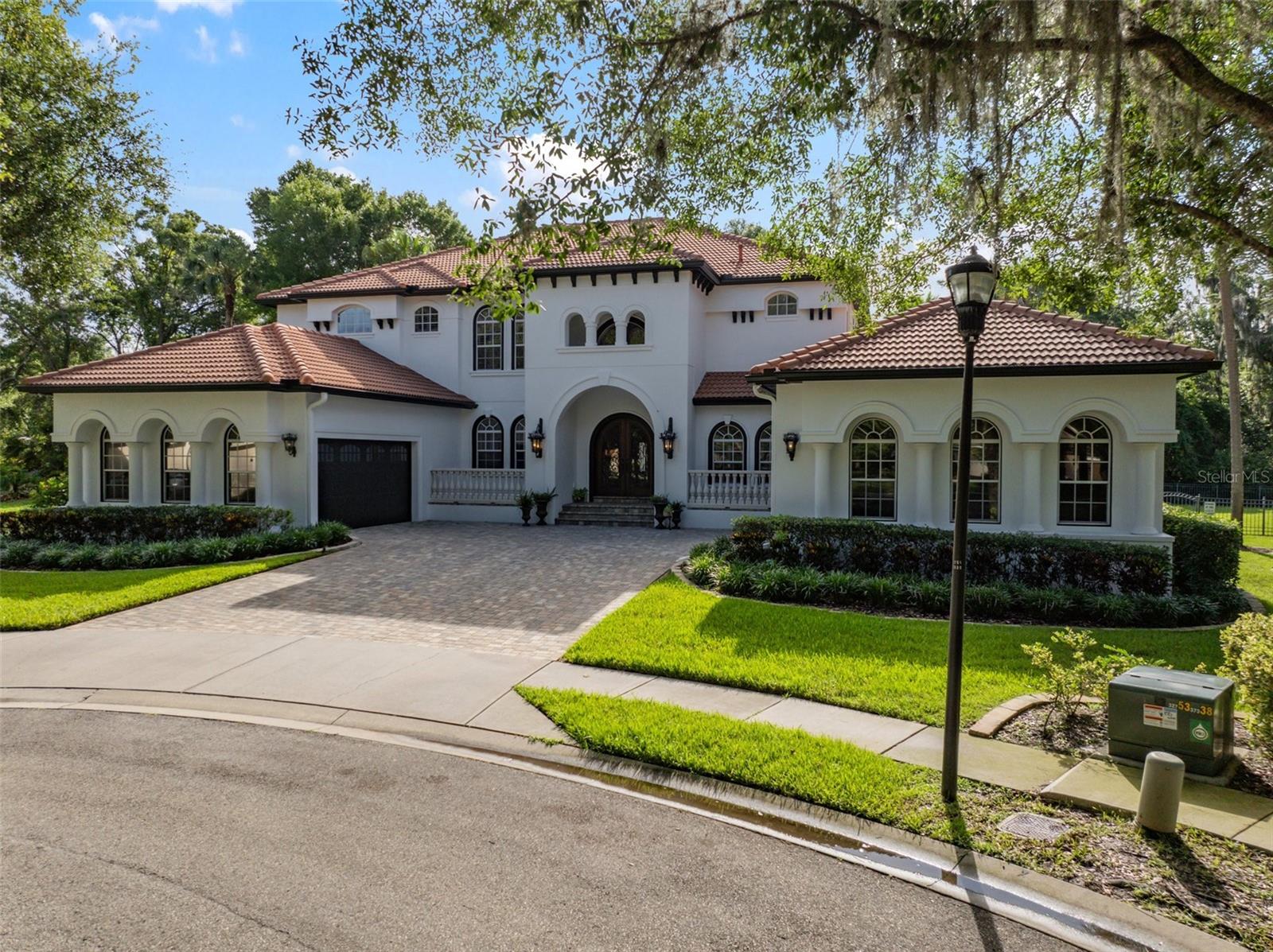 Exquisite Hannah Bartoletta Estate in gated Avocetview welcomes you! Elegance is found at the end of this roundabout in the heart of Fishhawk. Stately wooden doors, wrought iron accents, 'Bayshore' ballasts and a bricked courtyard command attention the moment you arrive. Step into the main entry hall and find yourself dwarfed by a towering 22 foot ceiling, looking up toward a grand spiral staircase and catwalk. The formal rooms include a spacious dining room and a living room or study with beautiful limestone hearth and fireplace. An intimate wine cellar under the stairs showcases your collection- complete with chiller and service bar. The family room, adorned with custom tray ceilings, plenty of windows and glass doors, offers a central space for everyone to gather. The kitchen in this home is sure to satisfy the yearnings of both gourmet and amateur chefs. Gas cooktop range, integrated fridge, wall oven and custom cabinetry are just a few of the special touches here. The breakfast room is enclosed with glass windows. This offers a stunning view into the custom outdoor entertainment space, featuring a fully equipped outdoor kitchen with piped natural gas, ice maker, beverage fridge and bar! There is plenty of room for socializing in the outdoor seating area & gas fireplace. Fantastic saltwater/solar heated pool and oversized spa complete with fountains & lighting. More Florida options are presented with an extended sun deck & covered dining space. Back inside, the primary suite creates a corner piece on the ground level. Warm wood-tone tiling and a beautiful stone fireplace make for a private retreat with gorgeous sitting area & private access to the pool. The ensuite bathroom exudes elegance with makeup vanity, 2 wash basin areas, Jacuzzi jetted tub and grotto style walk in shower. The owners' walk in wardrobe is showcased with chandelier lighting, custom cabinetry and a centerpiece dressing island. Also on the first floor is a beautiful study with a spacious wrap-around closet. This creates the perfect downstairs spare bedroom for guests. Upstairs beacons and among the oversized secondary bedrooms and well appointed bathrooms, you will be thrilled to find 'The Game room of Fishhawk'! This adult playground features a full bar, billiard & shuffleboard tables and is graced with more tray ceiling work & hardwood. SONY 4k 10 foot projection T.V. with surround sound, custom console, billiards & shuffleboard, lounge sectional are all staying here for the convenience of the new owner. Access the outdoor verandah and look out over your estates' backdrop. This is the perfect hideaway to enjoy the bouquet of a Tampa cigar. This fully fenced back yard on almost 1/2 acre creates a massive amount of green space & backs to conservation. This home also offers a 15 foot crafting room lined with cabinets and work desks. 2 half baths & multiple large walk in closets for hidden storage create convenience. Every window covered with custom shutters. Mechanically speaking, this home has been maintained with impeccable detail. Recent replacement of all 3 HVAC units, 2 tankless HWH & recent installation of solar heat pool system are examples. Utilities bills are kept to a minimum with reclaimed water for the 10 zone sprinkler system, low electric and gas bills! Fishhawk is wonderful with pools, nature trails, clubhouse, retail square, restaurants and is touted for it's schools. It is good to be home!