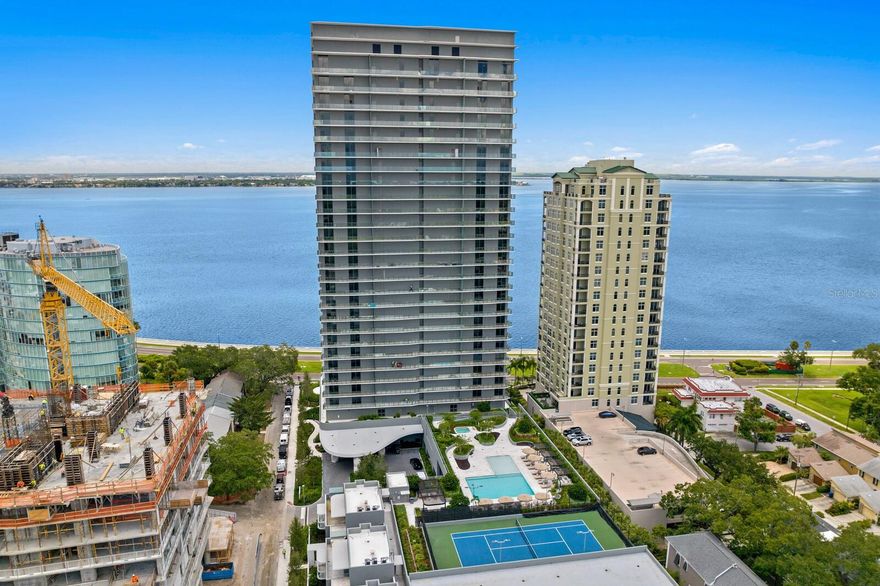 Nestled atop Tampa’s most iconic tower, this residence epitomizes sophistication combined with resort-style living at The Ritz-Carlton Residences, Tampa. This RARELY AVAILABLE 23rd floor END UNIT features breathtaking water views, with floor-to-ceiling glass walls and balconies on 3 sides, showcasing unparalleled panoramic vistas of Downtown Tampa, Hillsborough Bay, Tampa Bay, and Downtown St. Petersburg. The open floor plan with 10-foot ceilings provides a seamless flow between the living spaces, creating an inviting ambiance. With 3 large bedrooms, 3.5 baths, and a den offering flexible space, this residence is comfortable elegance. Enjoy sunrises on the oversized sunrise balcony overlooking iconic Bayshore Blvd. and Downtown Tampa, followed by evening sunsets on the oversized sunset balcony. The gourmet kitchen is equipped with top-of-the-line Sub-Zero and Wolf appliances, seamlessly integrated with bespoke marble waterfall countertops and elegant custom-designed Italian cabinetry by Italkraft. The large primary bedroom leads to an oversized custom closet and an opulent marble-clad spa-like bath with a soaking tub. High-end Kohler plumbing fixtures throughout the bathrooms add a touch of refinement. The laundry room features full-size, top-of-the-line washers and dryers. This unit already has DESIGNER LIGHTING and CUSTOM CLOSETS installed making this a turnkey purchase. The Ritz-Carlton resort lifestyle provides a tropical pool terrace with food and beverage options, state-of-the-art fitness center, spa services, a designated playroom, media lounge and golf simulator, pickleball and tennis courts, along with valet parking. A dedicated concierge is available to assist with personalized services, along with a 24/7 door attendant. Take a waterfront stroll along Bayshore Boulevard, known as one of the longest continuous sidewalks in the United States. Located near great shopping and restaurants, exhilarating nightlife and A-rated schools. Enjoy all the South Tampa lifestyle has to offer including walking and biking, an intrinsic art scene, sports venues, and the ease of access to airports and a vibrant downtown. Available FULLY FURNISHED at additional cost.