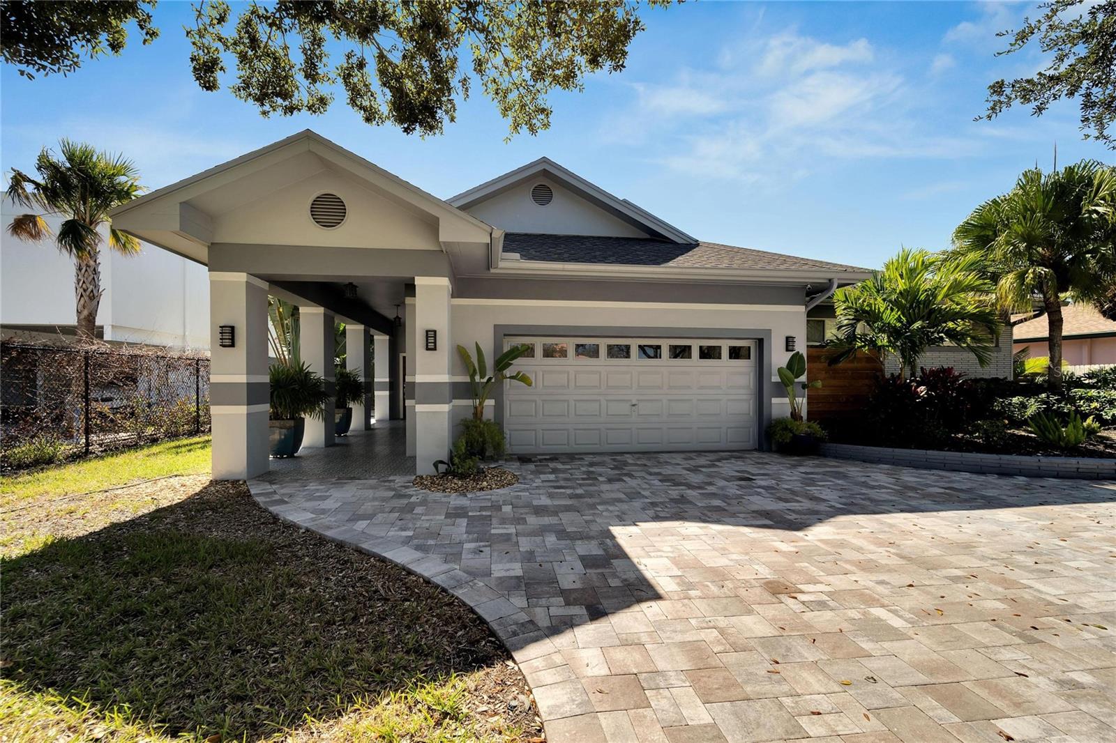 Presenting Sophistication meets Coastal Living on Paradise Island, Treasure Island. Luxury Waterfront residence features 2765 Sq. Ft with 4 bedrooms, 3 baths and a 2 car oversized garage. The Very Best of Luxe. Style and Texture flow throughout this well-appointed home. Excellent curb appeal with paved driveway, tiled front door entryway and dressed up landscaping that encompasses the property. The Gracious open living area features ceramic tile floors which flows through the living, dining and kitchen and hallways. Custom solar shades and valances offer a soothing color palette. The kitchen area has ample room for movement and activities and features a massive center island with a quality Quartz countertop and a deep ocean blue custom cabinet with pull outs beneath. Top of the line stainless steel sink and faucet. Opposite of the formable kitchen island are custom white wood kitchen cabinets with Leather Rain Drop Granite countertops. Featuring a spacious coffee bar, gas cooktop and sleek new stainless steel appliances. Spacious Owners Suite with custom solar shades, sliding doors to the pool and patio area and built-ins in closet area. The elegant bathroom is sophisticated and luxurious with duel vanities, large walk in shower and a water closet. Step outside to the newly paved shell stone patio area with new heated pool. This topical area is perfect for entertaining or sitting back to enjoy your water views. New pool equipment. New seawall 2023, new composite dock 2023 and new 10,000 LB boat lift with running water and electrical 2023. All interior doors were custom made. All new high end lighting fixtures throughout home. The 2nd and 3rd baths have been tastefully updated and are inviting and welcoming. New Roof 2019. 2 HVAC systems 2019. There is an oversized garage with new custom cabinets, storage space and workspace/work bench for the Mr. or Ms. Fix-it. This outstanding updated home has an unforgettable floor plan. 5 Treasure Lane is walking distance to the beaches, dining, shopping and entertainment.