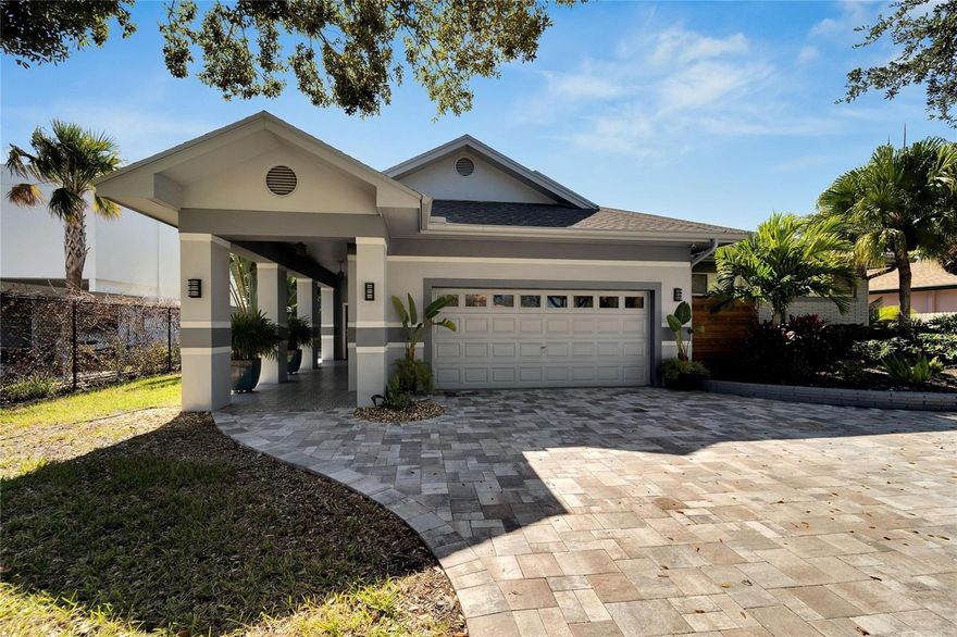 Presenting Sophistication meets Coastal Living on Paradise Island, Treasure Island. Luxury Waterfront residence features 2765 Sq. Ft with 4 bedrooms, 3 baths and a 2 car oversized garage. The Very Best of Luxe. Style and Texture flow throughout this well-appointed home. Excellent curb appeal with paved driveway, tiled front door entryway and dressed up landscaping that encompasses the property. The Gracious open living area features ceramic tile floors which flows through the living, dining and kitchen and hallways. Custom solar shades and valances offer a soothing color palette. The kitchen area has ample room for movement and activities and features a massive center island with a quality Quartz countertop and a deep ocean blue custom cabinet with pull outs beneath. Top of the line stainless steel sink and faucet. Opposite of the formable kitchen island are custom white wood kitchen cabinets with Leather Rain Drop Granite countertops. Featuring a spacious coffee bar, gas cooktop and sleek new stainless steel appliances. Spacious Owners Suite with custom solar shades, sliding doors to the pool and patio area and built-ins in closet area. The elegant bathroom is sophisticated and luxurious with duel vanities, large walk in shower and a water closet. Step outside to the newly paved shell stone patio area with new heated pool. This topical area is perfect for entertaining or sitting back to enjoy your water views.  New pool equipment. New seawall 2023, new composite dock 2023 and new 10,000 LB boat lift with running water and electrical 2023. All interior doors were custom made. All new high end lighting fixtures throughout home.  The 2nd and 3rd baths have been tastefully updated and are inviting and welcoming.   New Roof 2019. 2 HVAC systems 2019. There is an oversized garage with new custom cabinets, storage space and workspace/work bench for the Mr. or Ms. Fix-it.  This outstanding updated home has an unforgettable floor plan. 5 Treasure Lane is walking distance to the beaches, dining, shopping and entertainment.