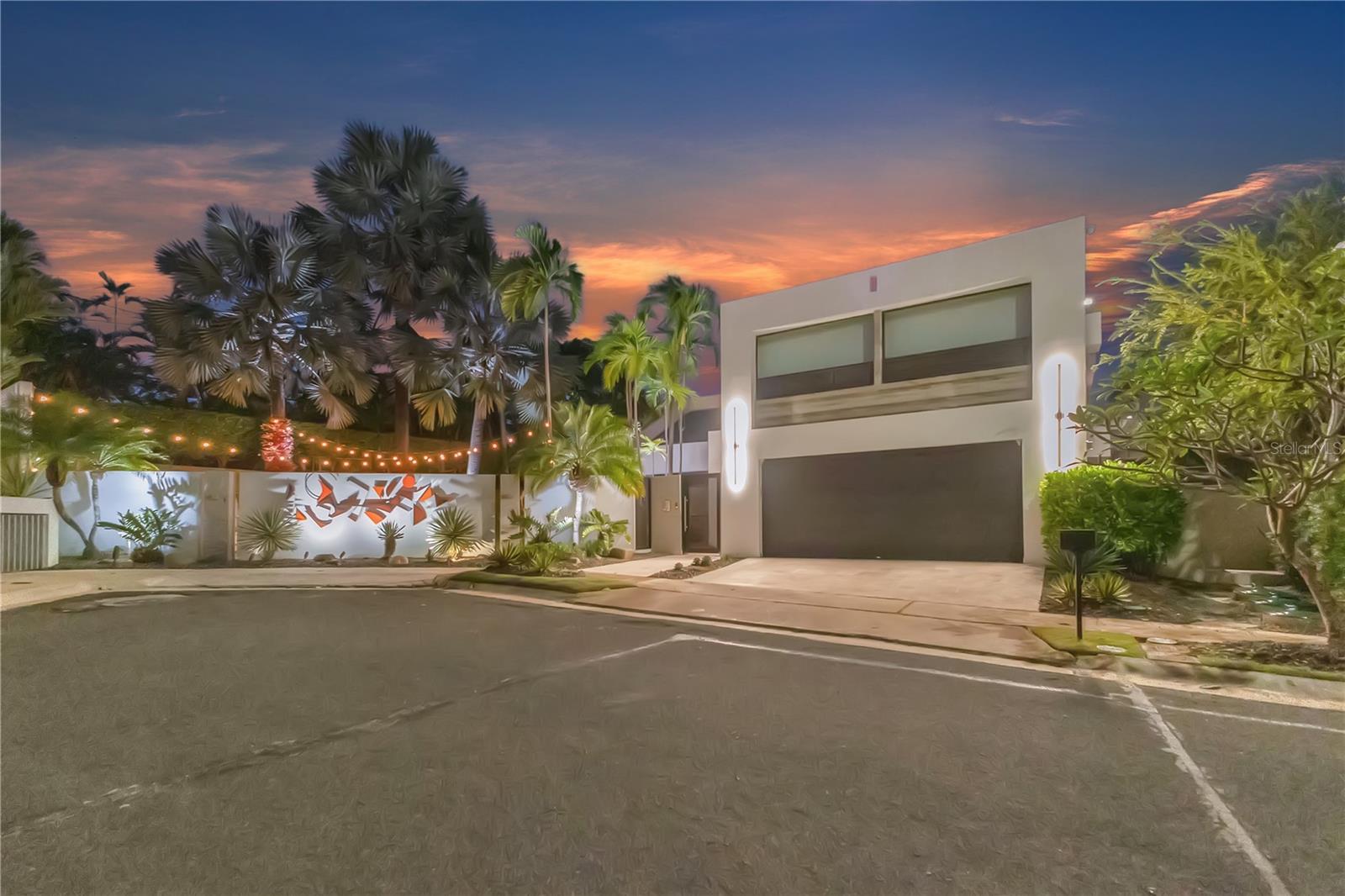 Nestled in the exclusive double-gated Estancias de Torrimar community in Guaynabo, this stunning corner-lot residence offers over 4,000 sq. ft. of elegant living space on an 827.71 m² cul-de-sac lot. Featuring 5 bedrooms and 4.5 bathrooms, this luxury residence includes a one-of-a-kind Master Suite with a private room, spa-inspired bathroom, and his-and-hers walk-in closets, a Junior Suite with a private bathroom and walk-in closet, and a versatile first-floor bedroom with full bathroom and independent entrance, offering flexible living options. Upscale
architectural finishes include fine travertine floors, marble vanities, custom walk-in closets, and custom lighting. A gourmet Italian Record Cucine kitchen with high end appliances and Neolith surfaces anchors the open floor plan, offering expansive outdoor views and multiple terraces. Additional features include a 300-bottle wine cellar, Sonos audio system throughout, travertine-tiled terrace, Firemagic gourmet BBQ and wet bar, saltwater pool, lush landscaping, EV chargers, full power generator, solar water heater, and a double garage. Move-in ready (“turn key”) and located within a prime zone of the community. Amenities include tennis, beach tennis, and pickleball courts, soccer and basketball courts, a playground, and 24/7 security. Prime location near top schools, restaurants, shopping, and highways. Private, luxurious, sophisticated, upscale living at its finest.