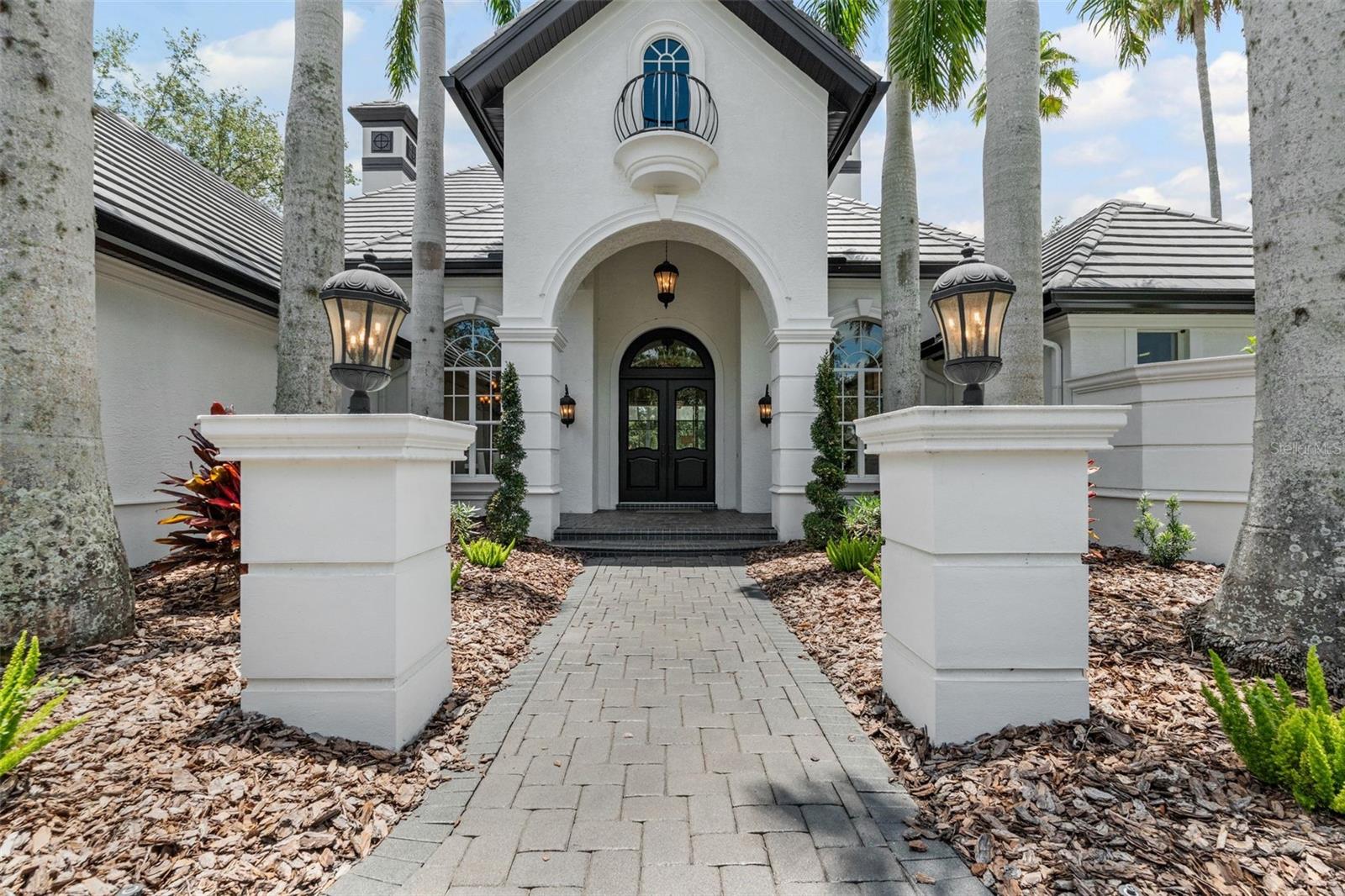 Welcome to Maison du Lac, an exquisite and timeless-designed residence nestled in the premier community of Lakewood Ranch Country Club. This location offers not only spacious and private lots but also the enchanting backdrop of a serene lake, complemented with a stunning saltwater pool & hot tub —perfect for relaxation and entertaining. As it is among the first communities in Lakewood Ranch - the HOA is with Town Hall and only $150/month. And the electricity is inside the hospital grid and has never gone out! Many upgrades - including a new tile roof and super systems make for easy living.
As you approach the home, you are greeted by a long tear-drop driveway framed by elegant columns bearing the name "Maison du Lac." This leads you into a circular driveway that provides easy access to the impressive entryway and around to the three-car garage. Upon entering, you are welcomed by a grand foyer that opens into the expansive Great Room, where natural light floods in, showcasing views of the pool and picturesque pond.
To your right, the inviting piano room adds a touch of sophistication, while to your left, the formal dining room awaits—ideal for hosting gatherings. The heart of the home is the Chef's Kitchen, equipped with top-of-the-line Thermador appliances, a reverse osmosis water system, a built-in coffee maker, and a convenient pot filler over the gas range. The kitchen also features a large eat-in breakfast area and a dedicated kitchen office for culinary enthusiasts.
The family room is designed for entertainment, boasting an impressive 85" screen TV and adjacent bonus room, perfect for movie nights or game days. This wing of the home includes two additional bedrooms and a full bathroom, ensuring ample space for family and guests.
Retreat to the luxurious Master Suite, which offers direct access to the pool and lake, creating a tranquil oasis. This suite features his and hers walk-in closets, as well as a lavish bathroom complete with both a soaking tub and a spacious shower, along with separate toilet rooms for convenience.
But the allure of Maison du Lac doesn't end here. Ascend to the upper level, where you'll find a captivating balcony that provides sweeping views of the surrounding landscape. This level also includes a game table, a full bath, and a bar area—perfect for entertaining or unwinding in style.
Live like royalty in this magnificent home, where every detail has been thoughtfully designed for luxury and comfort. Welcome to your dream home at Maison du Lac!