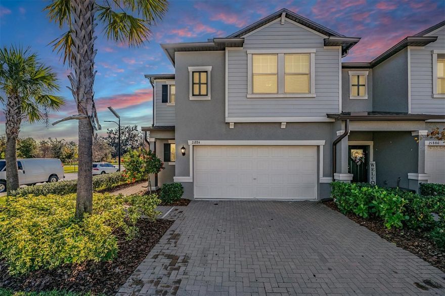 One or more photo(s) has been virtually staged. Welcome to this beautifully maintained end-unit townhome located at 21884 Lyonia Lane in the sought-after community of Connerton in Land O’ Lakes, FL. Boasting 3 spacious bedrooms, 2.5 bathrooms, and a generous 1,861 square feet, this corner-lot home offers both privacy and comfort with a 2-car garage and lush, well-manicured surroundings. Step inside to a bright, open-concept layout featuring tile flooring throughout the main living areas, high ceilings, and elegant crown molding. The modern kitchen is the heart of the home, complete with granite countertops, stainless steel appliances, white shaker-style cabinetry, a large center island with breakfast bar, and a walk-in pantry. Adjacent to the kitchen, the dining and family rooms create a seamless flow perfect for entertaining or everyday living. Sliding glass doors lead to a private covered patio and side yard, ideal for enjoying Florida's sunshine. Upstairs, a spacious bonus room/loft offers the perfect flex space for a second living area, playroom, or home office. The luxurious primary suite features a walk-in closet, double vanities with granite countertops, and a large walk-in shower. Two additional bedrooms are generously sized and share a full bath. A convenient upstairs laundry room adds to the home's functionality. This home is located in a prime position on a corner lot, offering more natural light and additional yard space. As a resident of the vibrant Connerton community, you'll enjoy access to resort-style amenities including a massive swimming pool with splash zone, fitness center, clubhouse, sports courts, walking trails, and more. Whether you’re looking for modern comfort, functional design, or a sense of community, this townhome checks all the boxes. Don’t miss your opportunity to own a move-in ready home in one of Land O’ Lakes’ most desirable neighborhoods!