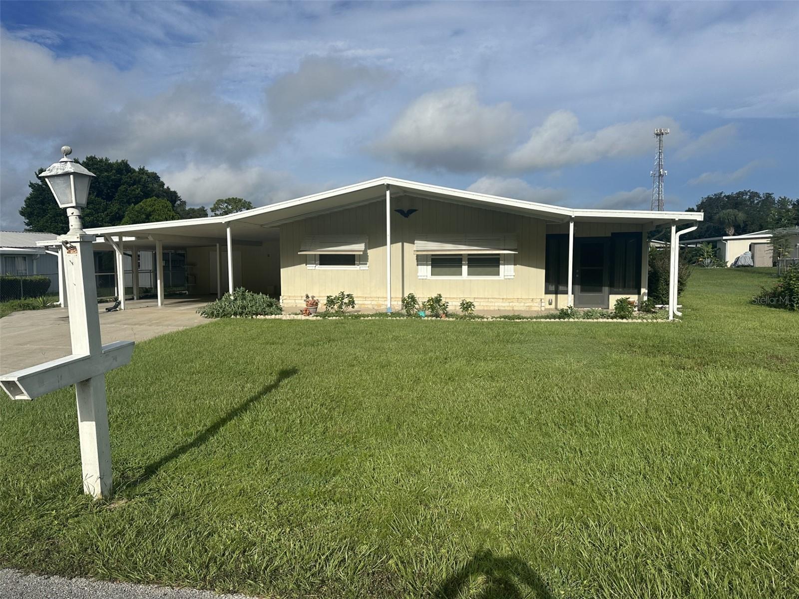 This wonderful 1144 square foot home offers 2 bedrooms, 2 baths, and a double carport, perfect for an active couple with hobbies. It boasts a spacious laundry room/workshop, plenty of carport space, and a large backyard. The roof is newer, and the A/C was updated in 2022. The front view features lovely trees, and a nearby golf cart path connects you to stores and dining. The lively community offers activities like card games, bingo, a pool hall, and two swimming pools. Nearby, you?ll find flea markets, antique car shows, and more. With quarter-acre lots, there?s room for gardening or other projects. Don?t miss out on this vibrant community and delightful home! Coffee time is Tuesday mornings at the first clubhouse, a great chance to meet neighbors.