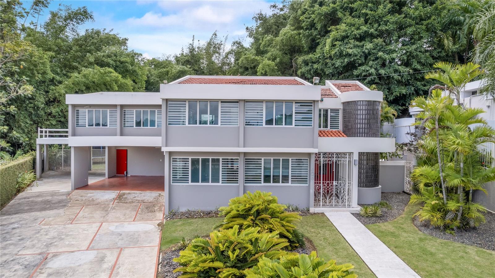 This residential property showcases a stunning contemporary design, spread across two levels and featuring an impressive backyard with a swimming pool. Having undergone a complete remodel in the 90s, the home boasts approximately 3,305 sq. ft. of living space situated on a generous 1,075 sq. meter lot.
- **Living Space**: 5 bedrooms and 5 bathrooms, along with an additional home office and a large laundry room located on the second floor.
- **Master Suite**: Spacious master bedroom equipped with a large walk-in closet and a luxurious bathroom featuring a spacious shower, toilet, bidet, and vanity.
- **Kitchen**: A modern kitchen equipped with stainless steel appliances.
- **Outdoor Spaces**: A concrete terrace measuring aprox. 900 sq. ft., spacious enough for gatherings, with a bar, storage space, and an exterior full bathroom. There's direct access from the terrace to the living, family, and kitchen areas.
- **Garage**: Two covered garages with a total capacity for 4 cars, with one conveniently located next to the kitchen entrance.
**Finishes and Equipment**:
- Marble floors in main living areas
- Split A/C units for climate control
- Security windows and doors for enhanced safety
- Water cistern and full power generator for convenience
- Alarm system for added security
**Community Amenities**:
- 24-hour gated community access
- Recreational and sports park nearby