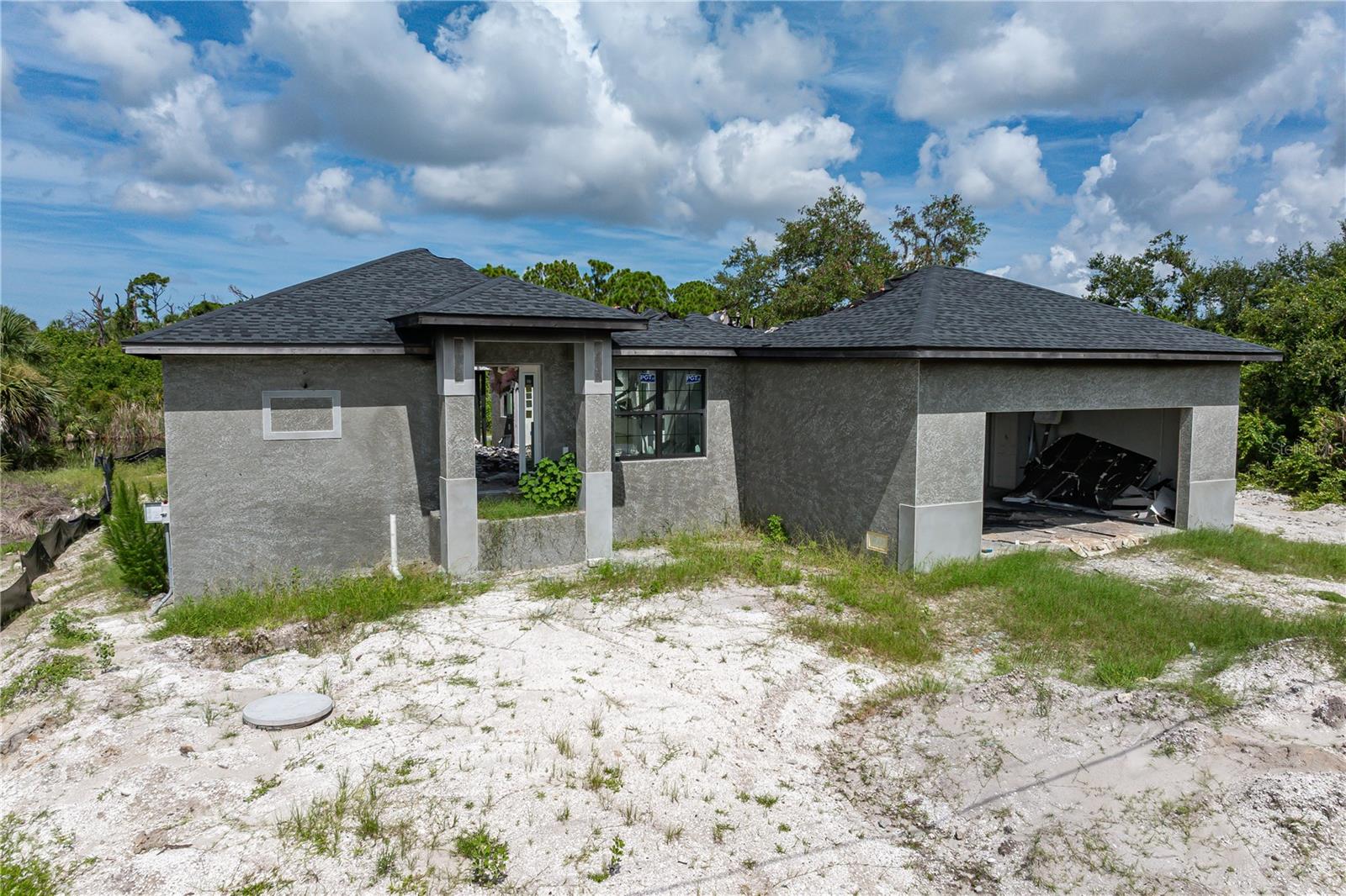 Under Construction. FIRE-DAMAGED, PARTIALLY COMPLETE, WATERFRONT HOME WITH POOL IN SOUTH GULF COVE – INVESTOR ALERT! Rare opportunity to acquire a canal-front, new-construction home in South Gulf Cove before completion—offered as-is after sustaining fire damage during the final stages of the build. This 3-bedroom, 2.5-bath, single-level home was thoughtfully designed with over 1,700 square feet under air, impact-resistant PGT windows and doors, and a shell for an in-ground pool already in place—offering a strong foundation for restoration or a rebuild. Situated on a canal with boating access to Charlotte Harbor and beyond, the lot features 80ft of waterfront and western rear exposure that will provide glorious sunsets beyond the canal. Inside, the structure remains intact in parts, including the garage, exterior block walls, and sections of the plumbing and framing. The floorplan was laid out with an open-concept great room/kitchen that transitions to a covered lanai through sliding glass doors. The builder’s intent is still visible in the layout, offering a desirable split-bedroom configuration and plenty of room for a modern, coastal-inspired interior. Outside, the pool shell is in place and awaits custom finishing touches. The property is cleared and ready for completion with utilities and infrastructure already in progress. Home is located in a growing area of South Gulf Cove, surrounded by new homes as well as other vacant home sites. It is close to area beaches, golf courses, and Boca Grande. There is an optional HOA that is more social in nature with access to the clubhouse, boat launch & group activities. Take part in the relaxed yet upscale boating lifestyle found here with miles of navigable canals. Buyers with vision will recognize the value in this location, existing structure, and potential. Whether restoring what's here or building new, this is a chance to invest in a highly sought-after waterfront community at a fraction of the price. Cash only.