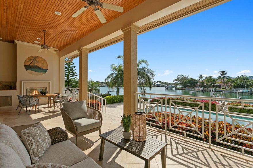 Coastal Elegance in the premier waterfront community of Yacht Club Estates. The perfect boater’s paradise is found in this outstanding waterfront location offering 75 feet of water frontage, generous dock, 11K lb lift and quick Gulf access. Custom built by Alvarez Homes in 2008, this elevated design features impact windows/doors, delivering refined living spaces and superior attention to detail. A dramatic custom double door entry welcomes you to 12-foot ceilings on the main living level, light-filled living spaces, coffered and tray ceilings, Santos Mahogany hardwood flooring and designer lighting. Arched cased openings provide an element of sophistication as they offer access to the formal dining room, formal living room with custom built-ins flanking a gas fireplace and water view beyond.  A generous open kitchen boasts top-of-the-line stainless appliances (Thermador/Bosch), 6 burner gas range, butler’s pantry, wine refrigeration, integrated cabinetry and granite counters, breakfast area, center island and breakfast bar overlooking the family room with an additional gas fireplace and French door access to the covered lanai. The first level also offers a guest bedroom, along with 1.5 baths (powder and pool bath). Upstairs provides two additional guest bedrooms and with Jack and Jill guest bath. The grand primary retreat features impressive custom closets, luxurious bath with whirlpool tub and spacious walk-in shower. Enjoy a morning bar in the upstairs hallway with sink and refrigerator. Outdoors, relax and entertain, embrace captivating sunsets and dolphins at play, with a 39-foot saltwater lap pool and expansive paver surround, a covered lanai, outdoor kitchen and fireplace at the water’s edge. A fully equipped dock offers water, power, shower and lighting. Additional features include an elevator, surround sound, security system, hurricane rated windows/doors, Kinetico water softener, a full irrigation system, mature landscaping and 3-car garage. Minutes to the Gulf and beaches, culture and nightlife, Yacht Club Estates’ coveted neighborhood offers an active Gulf Coast lifestyle with boating club, bike club and more.