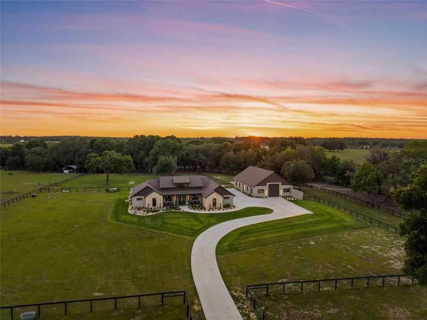 In the heart of Marion County horse country, about 5 minutes from the World Equestrian Center and 18 minutes to HITS, this breathtaking custom gated equestrian estate offers the perfect blend of timeless architecture, modern elegance and top-tier construction. Set on 10 picturesque acres, with an additional 10 acres available, this newly built residence features over 3,800 sqft of thoughtfully designed living space, with 4 bedrooms, 4 baths, and a fabulous office with built-ins, all arranged in a multi-split layout for maximum comfort and privacy. The main living areas are designed for effortless indoor-outdoor entertainment, anchored by a stunning gourmet kitchen with custom cabinetry, an oversized island, dual refrigerators, double ovens, a full beverage center, and premium ZLINE appliances with champagne accents. The private primary suite is a true retreat, dual vanities, a walk-in rain shower and an incredible custom closet with it's own dedicated laundry. Two guest suites are located on the main level, while an upstairs bonus room offers a secluded space with panoramic farm views—ideal for guests, private escape or in-laws, as well as a finished room for additional storage, currently being used as a wine cellar. The 56’ x 64’ concrete block barn is built for versatility, with spray foam insulation, tongue-and-groove ceilings, and two 14’ roll-up doors offering the space and height for your RV, boat or equipment and culminated with 5 interior and 5 exterior stalls, wash rack and a 450 sqft office with kitchenette, full bathroom and laundry. Construction highlights include block construction throughout, spray foam insulation, Anderson windows, porcelain tile flooring, gorgeous custom cabinetry, quartz countertops, 8-foot doors and tongue-and-groove soffits. Perimeter fencing, multiple paddocks, a 900-foot paved drive, 26KW whole-property generator with a 250-gallon buried propane tank and an advanced well system delivering strong, consistent pressure complete this exquisite and turnkey equestrian estate in one of Ocala’s most desirable locations.