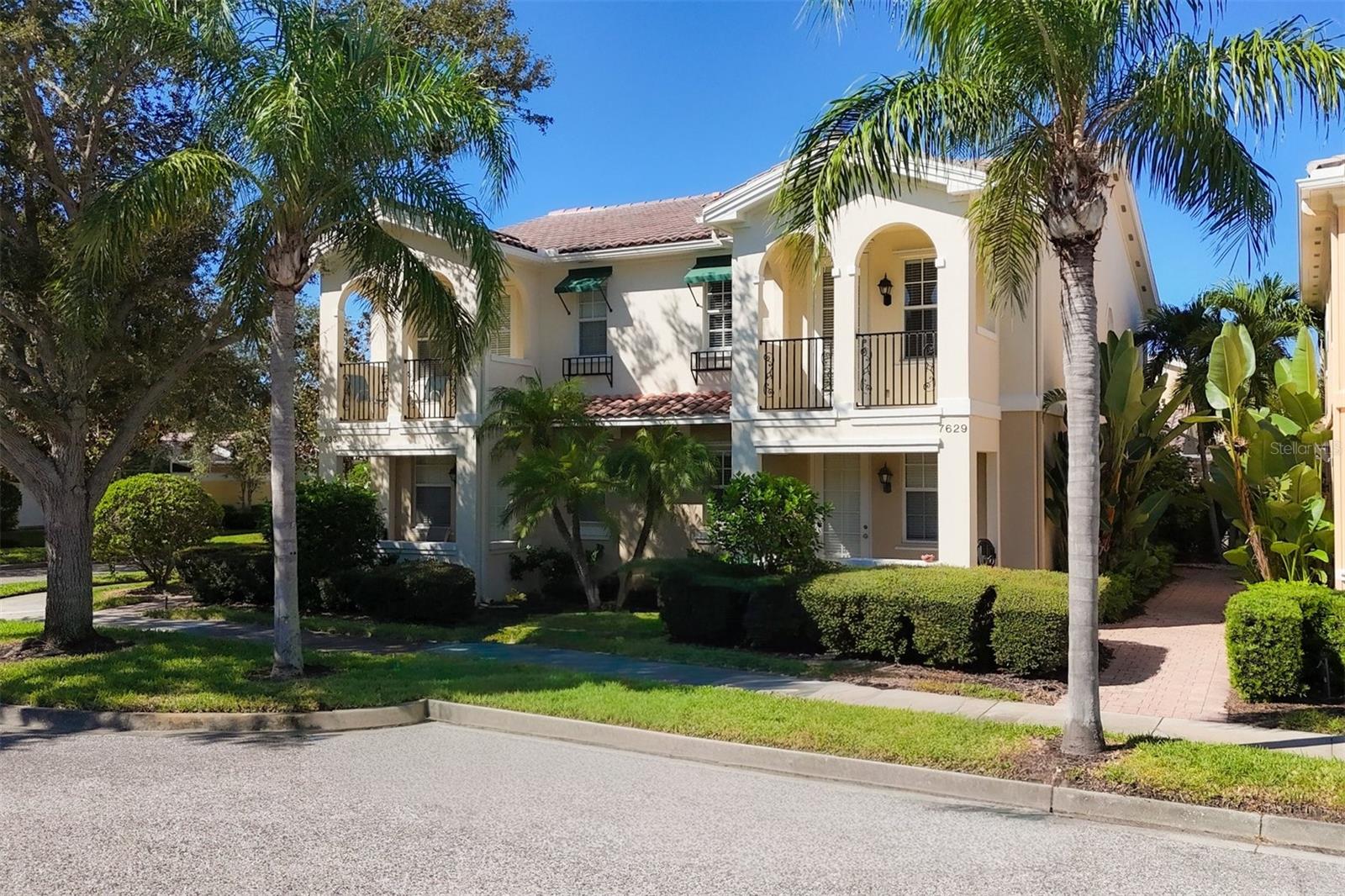 Welcome to one of the most desirable, maintenance-free Palmer Ranch communities...in resort-style VILLAGEWALK! This 3 bedroom, 3 bath, "Cayman model" is charming and practical. These were built by Divosta with reinforced steel and poured concrete walls, armed with hurricane shutters and impact glass doors! Inside you are greeted with loads of natural light, a wide open floor plan, and all NEWER luxury vinyl plank flooring throughout this impressive home! Kitchen boasts modern, 1 year old stainless steel appliances, and lots of cabinet storage and counter space. You can choose which of the 3 generous primary bedrooms you want.. as each has a roomy, walk-in closet with built-ins, and an ensuite full bath. Or make the downstairs bedroom, with your personal walk-out lanai, your office/den, you decide! Upstairs you can choose a bedroom that enjoys a private, quaint balcony overlooking the lush, tropical landscapes or a larger one with a cozy nook for a desk, lounging, or a craft space. Upstairs laundry room has a useful utility sink and handy cabinet storage. Downstairs, bask in the Florida sunshine all year-round in your expansive screened-in lanai off of the Great room. A retractable canopy awning makes entertaining easy, and provides shade when you want it! Perfect spot to grill and relax. The 2 car garage allows room to park your golf cart, car, and still room for your beach toys and sports equipment, the poured, epoxy garage floor is a bonus. Another perk is an in-house vacuum system, tucked away under the stairs in your extra large storage room. Being a member of this award winning, gated community is more than a place to live, it's a place to call home and live your Best Florida lifestyle! Top notch amenities include the waterfront Town Center, post office, salon, gas station, full service cafe, meeting rooms, lap and lagoon pools, 6 Har-tru lighted tennis courts, pickleball, bocce, basketball court, well-equipped fitness center, gift shop, lagoon tiki bar, and miles of walking/biking trails to enjoy the abundant nature in this 500+ acres of manicured and landscaped community preserve. There is a full calendar of clubs and activities to join, for all ages! Villagewalk's location is prime, close to "A" schools, Legacy Trail, Siesta Key and area beaches, shopping, Costco, golf courses, parks, the arts culture scene and all Sarasota and Venice has to offer! Come see why Villagewalk is Home!