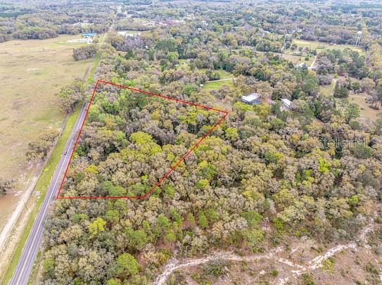Beautiful estate lot for sale on scenic Archer Road with beautiful elevations. Currently wooded with mature live oaks and other hardwoods. Flood zone X with natural retention area at base of property. 5.88 acres. Amazing views of farmland. Old world Florida charm. Open builder; no known deed restrictions. Minutes to Archer, UF and VA Hospital.