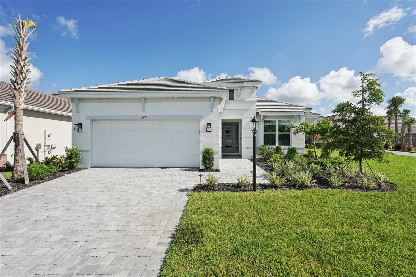 DON'T LOOK AT A WALL. Welcome to your BRAND NEW and upgraded 3-bedroom, 3-bathroom single-family home with a den on a premium lake lot in the sought-after Esplanade at Azario. This stunning residence features a tandem 3-car garage designed with luxury and functionality in mind. While golf is not deeded to the property, independent golf memberships can be obtained at the community's pro shop. Unique features and upgrades include a GOURMET KITCHEN complete with a range hood, gas cooktop, a 56-bottle wine fridge, and 42” soft-close cabinets. The home boasts 10’ tray ceilings with double crown molding, 8’ closet doors, and an extended covered lanai pre-plumbed and pre-wired for outdoor entertaining and a future pool. Additional enhancements include epoxy-coated garage floors, full landscape lighting with pathway, flower bed, palm tree uplighting, and prewiring for front and rear security cameras. Lawn maintenance is included in the HOA fees, offering convenience and peace of mind. Location & Community Features This home offers unparalleled privacy and access to resort-style living, situated in the exclusive gated community of Esplanade at Azario within the Lakewood Ranch. Indulge in various on-site amenities, including a culinary dining experience, casual poolside drinks, and numerous social and wellness activities. Community highlights feature an 18-hole championship golf course (with membership options), a pro shop and bunker bar, an aqua driving range, a full-time activities director, a resort-style pool with a poolside Bahama Bar, a spa/wellness center, and a culinary center with a teaching kitchen. Additional amenities include a state-of-the-art fitness center, clubhouse, 16 pickleball courts, 6 Har-Tru tennis courts, bocce ball courts, walking trails, a dog park, and flexible space for gaming and meetings. This exceptional home and vibrant community provide the perfect blend of luxury, comfort, and active living!
