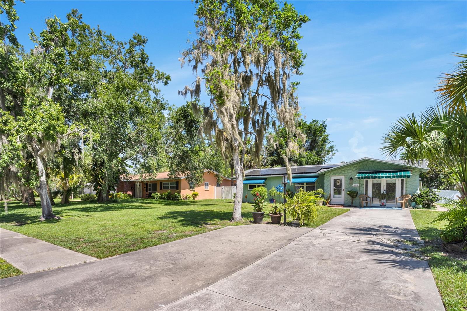 This meticulously cared for and renovated 3 bedroom, 2 bathroom home is sited on a large lot on a picturesque street less than a mile from the shops and restaurants of downtown New Port Richey. The front entry leads to a bright and airy living room, which has the low-maintenance wood-look tile found throughout the home. The kitchen has been fully remodeled with high-end finishes including custom cabinetry, beautiful leathered granite countertops, a beveled tile backsplash with accent tile, high-end appliances and custom hand-blown pendants commissioned by a glass artisan. Off the kitchen is a formal dining room, which leads to an enclosed porch with ample space for indoor-outdoor living and entertaining.The primary bedroom suite has a beautifully designed full bathroom - both with accessibility features, with wide doorways, French exterior doors and a large tiled shower. Two additional bedrooms share the second full bathroom. The fully fenced backyard has a garden house and chicken coop and paver patio area. The detached garage is accessed by an alley behind the home and has space for two cars and has a built-in workbench, offering parking options in both the front and rear of the home. This home also includes smart features, new HVAC including ductwork (2023) and vinyl double-paned windows (2014), as well as owned solar panels which have kept the seller’s electric bills at only the monthly usage fee of $43. Owner-agent related.
