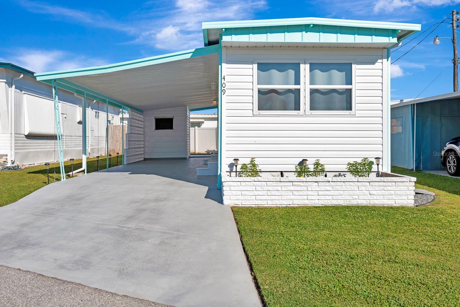 This beautifully remodeled 1-bedroom, 1-bath mobile home is move-in ready and shines with pride of ownership. Step inside to find an updated kitchen featuring stainless steel appliances, newer cabinets, and modern finishes. The spacious living area and bedroom feature luxury vinyl plank flooring throughout, complemented by newer windows and siding for improved comfort and efficiency. The bathroom has been tastefully updated, and the home includes a washer and dryer for your convenience. Enjoy the ease of low-maintenance living—the HOA covers water, trash, and sewer—so you can focus on enjoying your home. Outside, you'll appreciate the covered carport with room for two cars and a cozy outdoor space perfect for relaxing. This home is being sold fully furnished, making it an ideal option for year-round living or a seasonal retreat. Don’t miss this turnkey opportunity to own a beautifully updated and fully furnished home that’s ready for you to move right in!