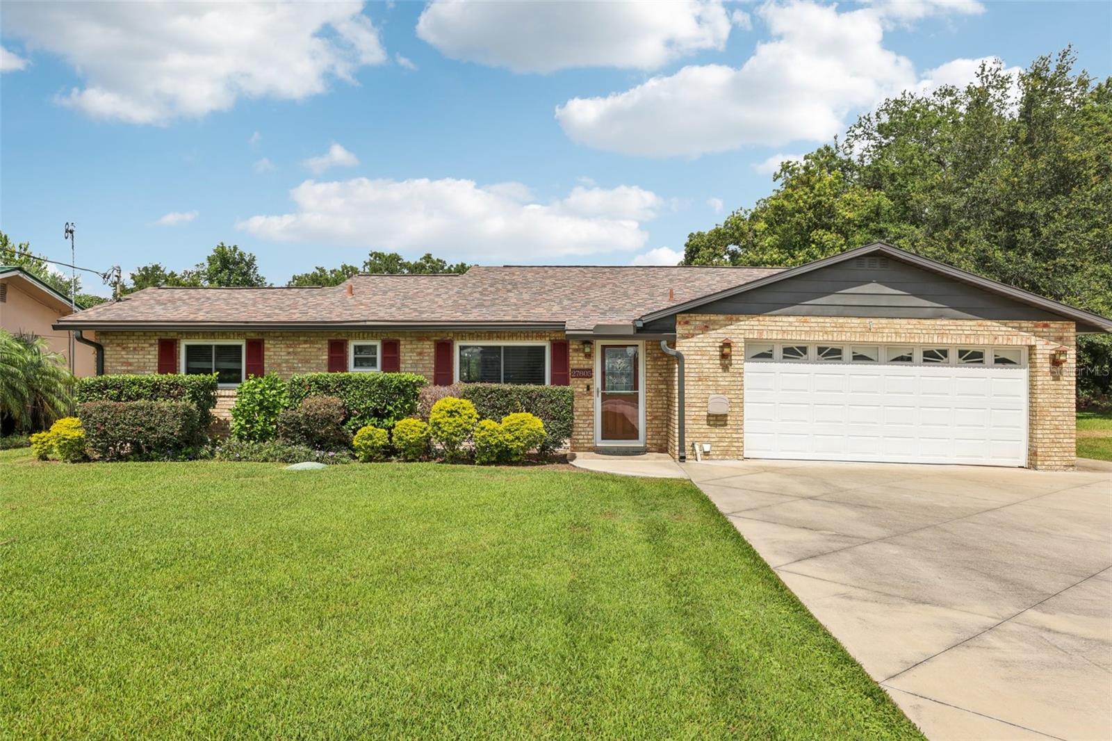 Don't miss this opportunity to own a beautifully remodelled and updated home with direct access to the Harris Chain of Lakes and some of Central Florida's best bass fishing. 27805 Lois Dr offers the perfect launching point for anglers looking to maximize their time on the water. Launch from your private dock or from many ramps located across the Harris Chain. This move-in ready 2/2 with split floor plan boasts a dream kitchen with expansive bevelled-edge granite island; complete with surround under-counter storage. The specifications of the upgrades in this home are impressive; with granite backsplashes / soft close, solid wood kitchen cabinetry with great roll-outs and features and Samsung Black stainless appliances included in the sale. Two well appointed bedrooms with two full bathrooms, one with marble shower with his/her shower heads. The open-plan living area provides ample space for entertaining / dining and a home office. The double aspect windows provide views over well established gardens and the new sliders open into a wrap around glass-screened lanai with tile flooring.*** Roof 2017 *** LVP Flooring throughout living area *** Hybrid Water Heater *** This home has a fenced rear yard, with double gates for access, beautiful new pavers that wind through the garden and around the home and a 30ft wide driveway that will easily accommodate truck / boat / trailer. *** No HOA *** Unincorporated Lake County so cost efficient. *** Dock & Boat House with lift that can accommodate up to 22ft TriToon (seller will leave adapting blocks for V-Hull). Walkways on dock are new *** Windows 2016 & Picture windows / Sliders replaced 2023 ***