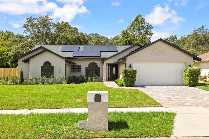 809 Burr Oak Drive sits on a gorgeous corner lot with striking curb appeal, fully upgraded with a new paver driveway and walkway, fresh sod, sprinklers, and a fenced backyard. This three-bedroom, two-bath home with a flexible Florida room/office has been updated with a two-year-old roof and paid-off solar, brand-new HVAC, and repiped plumbing. Inside, tall vaulted ceilings and a split layout highlight high-quality finishes throughout, including custom trim, a designer chandelier, sconces, and new luxury vinyl plank flooring. The living room features a custom entertainment centerpiece, while the family room offers a floor-to-ceiling wood-burning fireplace. The kitchen is fully renovated with solid-wood shaker cabinetry, quartz countertops, marble backsplash, stainless steel appliances, a microwave drawer, and an island with bar seating. The Florida room with French doors adds natural light and flexibility for work or entertaining. The primary suite includes a walk-in closet and a spa-like bath with a floating walnut vanity, quartz counters, soaking tub, and a walk-in shower with dual shower heads. Two additional bedrooms share a modernized bath with furniture-style vanity and marble tile. Outdoors, the paver patio and expansive fenced yard create endless options for entertaining or play. Community amenities include tennis courts, basketball hoops, and a playground, with Publix, schools, shopping, and major highways only minutes away. This home blends curb appeal, high-quality finishes, and convenience—schedule your private showing today.