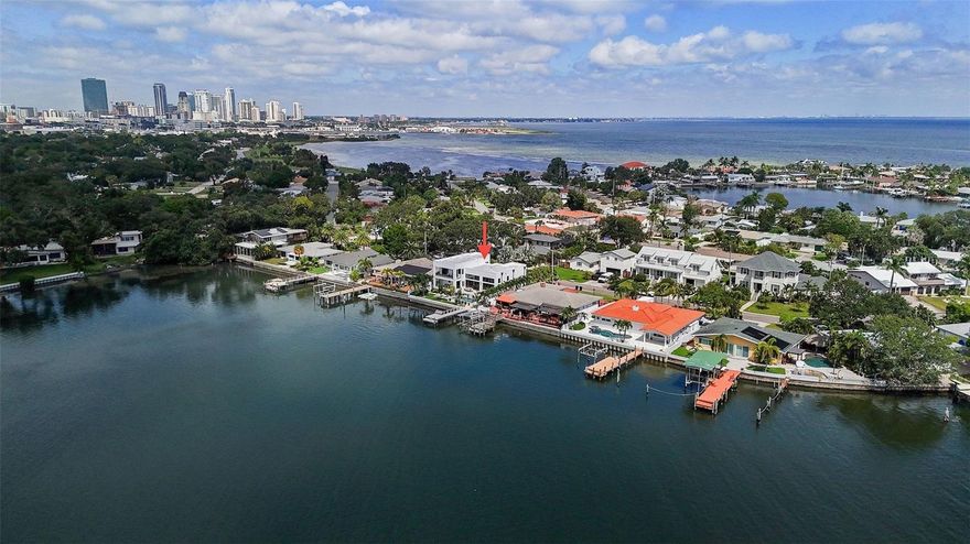 Paradise awaits you in this  2018 meticulously built custom home by Triple Point Design located in Tropical Shores, only 1.5 miles from downtown St. Pete. From the moment you walk up to the entrance, you will understand how special this home is from the stunning solid wood pivot door to the beautiful sculpture that greets your guests.   Imagine walking in your front door everyday to be treated to the breathtaking views of Big Bayou.  The main living area has  14' ceilings with floor to ceiling water views with  two separate seating areas with a see through fireplace between them. Open your accordion glass doors and step out onto a patio that overlooks your pool, private dock and green space for the dogs. If you like to entertain, your guests will never want to leave your 75’ open water view of Big Bayou, which is a boater's dream.

Back inside, your chef's kitchen, with 9' ceilings , features Bosch appliances, including a built-in coffee bar. The soft close cabinets and doors are made of zebra wood and oak and add an unmatched sophistication as you prepare your meals overlooking a large island and seating area. Not only does the kitchen offer an abundance of storage, but there is an additional butler's pantry as well as a large wine refrigerator right off the kitchen.  The primary suite is located on the second floor with nothing short of amazing water views to wake up to every morning.  The attached ensuite is too stunning to describe in words with its large designer walk in closet!

The home features a whole house propane generator for an additional piece of mind and no flood waters entered the home or garage.

You do not want to miss this rare opportunity to move into your turnkey dream home!