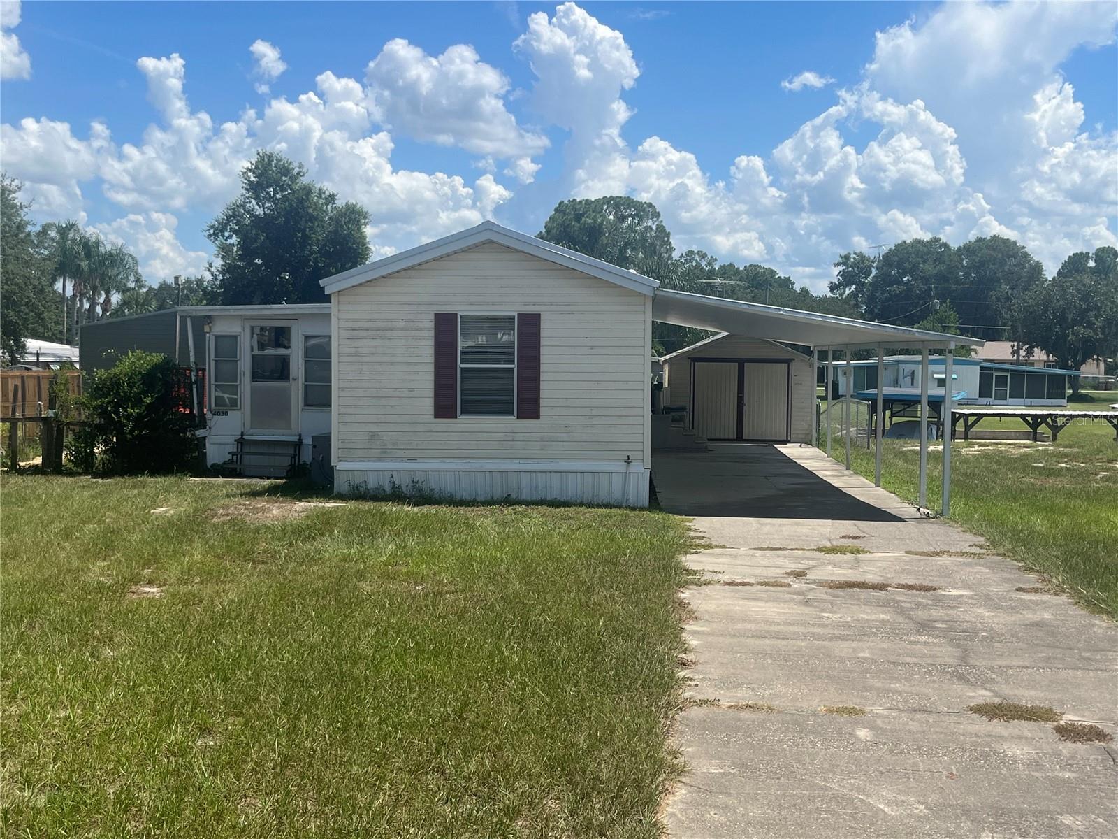 Check out this Chain of Lakes canal front home under $200K! Boasting a metal roof, an open floor plan with vaulted ceilings, and plenty of interior storage space, this home welcomes you with ease. Spend weekends cruising through the Chain of Lakes, fishing, and exploring some of our lake side restaurants. The porch is great for evening cook outs, looking at the view or fishing some more from your backyard. No HOA, and you own this oversize lot! The lot also contains two large storage sheds and an extra large carport for a boat or RV. This home is being sold as-is and is ready for you to make this oasis your own!