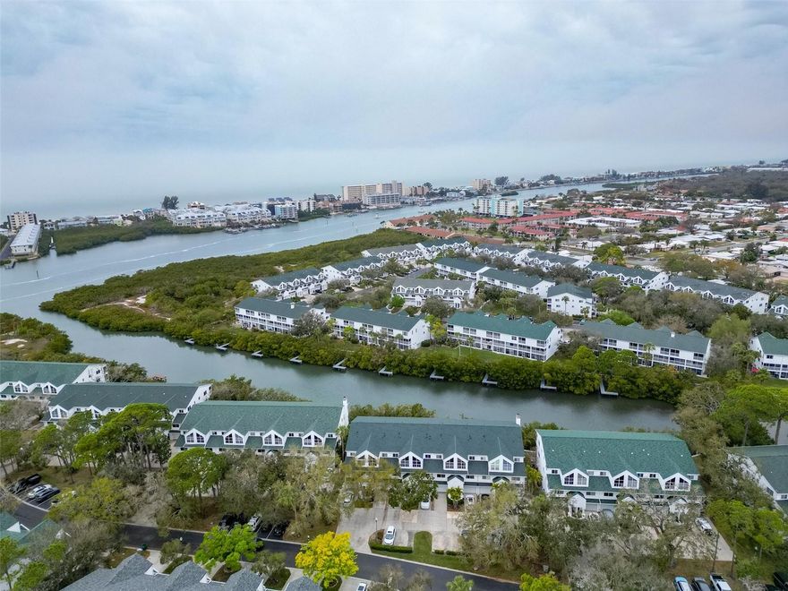 Think the perfect low maintenance WATERFRONT LIVING can’t be yours? THINK AGAIN! Old Florida charm and the perfect Florida waterfront lifestyle are YOURS in this spacious peaceful high and dry elevation (level 2) 3-floor townhome with multiple water views and dock access located in the highly sought after city of Seminole. This is the perfect space to have your key lime pie…and eat it too!
All the joys of living on the water and none of the stress! 
With TWO large living rooms on separate floors, this home seems like two homes in one and works great for multigenerational families or company that comes frequently! 
The open concept second floor living space has a kitchen with beautiful custom solid wood cabinetry with crown molding, stone countertops, and a high end wood range hood combined with the beautiful designer dining room chandelier and spacious living room that leads out to your screened in balcony overlooking the tranquil water leading out into the bay.   
Upstairs on the third floor (which is handicap accessible) you will find that there are basically two primary suites with high cathedral ceilings! The primary with the waterfront view has not one, but TWO large walk-in closets, an en-suite bathroom, and a private screened-in balcony overlooking the sparkling water while the other also has its own en- suite bathroom, double built-in closets, and bonus space with built-in shelving and vaulted ceiling perfect for a home office or workout area! The third bedroom is located on the second floor and has a built-in closet with a large extra storage compartment inside. 
Downstairs to the first floor (handicap accessible) you will find a second living space and full bathroom! Perfect for guests, family, or just extra space to entertain. The sliding glass doors open to the gated back porch with views of the wildlife and water with a pathway leading out to the dock for fishing, hopping on your canoe, kayak, paddleboard, or just simply sitting, watching, and listening to nature in this protected tropical preserve. All sliding glass doors are equipped with electronic storm shutters for extra wind protection. 
This beautiful and peaceful community is both pet friendly and has a heated pool with lounge chairs and tables making being social a breeze and features plenty of guest parking. 
Updates include: Acorn electronic handicap chair lift for stair access to all three floors (removable), Hurricane grade garage door, hurricane shutters on all glass doors, New A/C (2025), New Roof (2025), High end Bosch dishwasher (2024), High-end chandelier, kayak rack in garage.