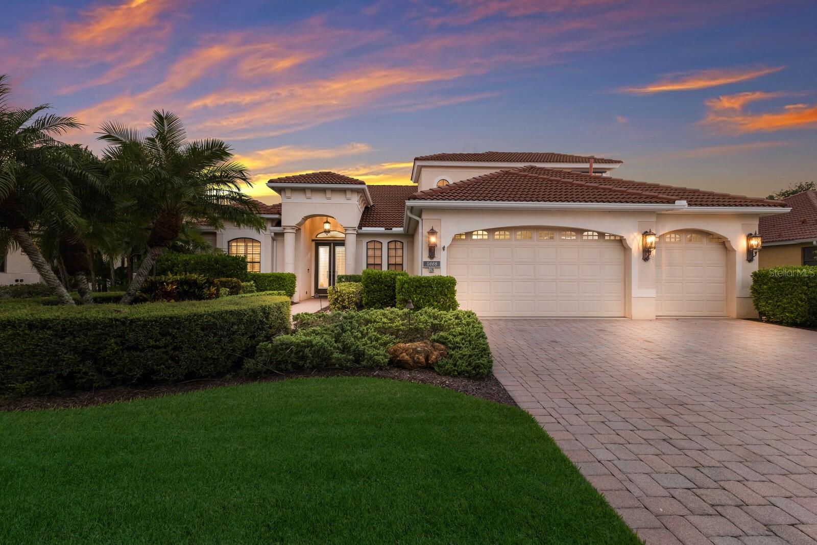 The Belle of the Ball in Tuscana! This grand custom residence by renowned area builder Lee Wetherington Homes, is perfectly situated on a private, walled, and meticulously landscaped homesite in a highly coveted Sarasota neighborhood known for its A rated schools, ambiance, and location. Exceptional design and luxury is found at every turn, as this home stands out from the rest for its elegance, smart home capability, and one-of-a-kind entertainment deck that redefines outdoor Florida living. Built with the comfort of family and guests in mind, there are 4 true bedrooms, 3.5 bathrooms PLUS a large bonus room. Interiors are a complementary pallet of neutral tones, natural light, and an unparalleled level of finish found in few other homes such as 10 inch crown moldings throughout, stone surfaces, automated shades, custom millwork, intelligent lighting systems, and is prewired with state of the art CAT 5 & 6 wiring, indoor and outdoor speakers throughout, and thermal sensing camera systems, all ready for a new owner to connect to a Savant or similar system which could control lighting, climate, music, video, and more from anywhere. A natural gas equipped kitchen with glass tile backsplash, glass-front cabinetry, inset lighting, and stainless appliances are at the center of the home and provides the perfect space for preparing an exquisite meal. The inviting family room boasts a sleek linear fireplace with porcelain accent wall. Further wow guests as the climate-controlled wine cellar is a dream for any wine connoisseur—with storage for over 900 bottles, elegant, functional, and the ultimate entertaining asset. Every room of the main living area has advantageous views of a stunning backyard oasis through impressive NanaWall style folding glass doors. Fold them out of sight to unveil your own private retreat with expansive travertine pool deck, gas heated saltwater pool and spa, and finally Florida living is yours with the show-stopping 500 sq ft cabana adorned with tongue and groove ceilings, a 30-foot fully equipped summer kitchen, and spacious dining and lounge areas all accented by an LED lighting package and protected by PGT windows. Peace of mind is yours as this home boasts an impressive 48kw whole house Generac generator that allows uninterrupted enjoyment of every major system on full power no matter the weather. This extraordinary property truly has it all—style, technology, luxury, and comfort. Whether hosting lavish gatherings or enjoying peaceful evenings at home, this Tuscana treasure is ready for its next owner to enjoy.