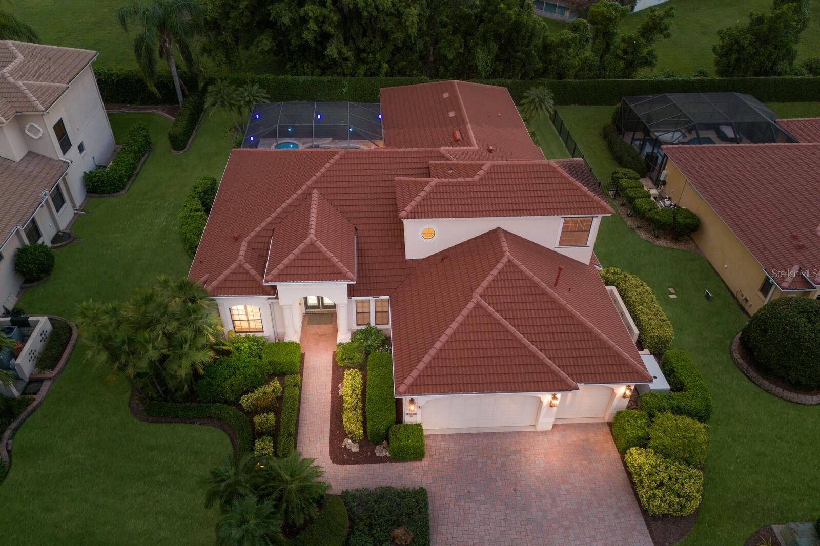 The Belle of the Ball in Tuscana! This grand custom residence by renowned area builder Lee Wetherington Homes, is perfectly situated on a private, walled, and meticulously landscaped homesite in a highly coveted Sarasota neighborhood known for its A rated schools, ambiance, and location. Exceptional design and luxury is found at every turn, as this home stands out from the rest for its elegance, smart home capability, and one-of-a-kind entertainment deck that redefines outdoor Florida living. Built with the comfort of family and guests in mind, there are 4 true bedrooms, 3.5 bathrooms PLUS a large bonus room. Interiors are a complementary pallet of neutral tones, natural light, and an unparalleled level of finish found in few other homes such as 10 inch crown moldings throughout, stone surfaces, automated shades, custom millwork, intelligent lighting systems, and is prewired with state of the art CAT 5 & 6 wiring, indoor and outdoor speakers throughout, and thermal sensing camera systems, all ready for a new owner to connect to a Savant or similar system which could control lighting, climate, music, video, and more from anywhere. A natural gas equipped kitchen with glass tile backsplash, glass-front cabinetry, inset lighting, and stainless appliances are at the center of the home and provides the perfect space for preparing an exquisite meal. The inviting family room boasts a sleek linear fireplace with porcelain accent wall. Further wow guests as the climate-controlled wine cellar is a dream for any wine connoisseur—with storage for over 900 bottles, elegant, functional, and the ultimate entertaining asset. Every room of the main living area has advantageous views of a stunning backyard oasis through impressive NanaWall style folding glass doors. Fold them out of sight to unveil your own private retreat with expansive travertine pool deck, gas heated saltwater pool and spa, and finally Florida living is yours with the show-stopping 500 sq ft cabana adorned with tongue and groove ceilings, a 30-foot fully equipped summer kitchen, and spacious dining and lounge areas all accented by an LED lighting package and protected by PGT windows. Peace of mind is yours as this home boasts an impressive 48kw whole house Generac generator that allows uninterrupted enjoyment of every major system on full power no matter the weather. This extraordinary property truly has it all—style, technology, luxury, and comfort. Whether hosting lavish gatherings or enjoying peaceful evenings at home, this Tuscana treasure is ready for its next owner to enjoy.