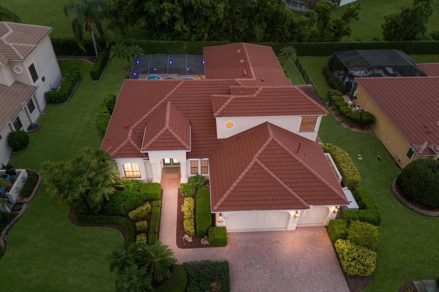 The Belle of the Ball in Tuscana! This grand custom residence by renowned area builder Lee Wetherington Homes, is perfectly situated on a private, walled, and meticulously landscaped homesite in a highly coveted Sarasota neighborhood known for its A rated schools, ambiance, and location. Exceptional design and luxury is found at every turn, as this home stands out from the rest for its elegance, smart home capability, and one-of-a-kind entertainment deck that redefines outdoor Florida living. Built with the comfort of family and guests in mind, there are 4 true bedrooms, 3.5 bathrooms PLUS a large bonus room. Interiors are a complementary pallet of neutral tones, natural light, and an unparalleled level of finish found in few other homes such as 10 inch crown moldings throughout, stone surfaces, automated shades, custom millwork, intelligent lighting systems, and is prewired with state of the art CAT 5 & 6 wiring, indoor and outdoor speakers throughout, and thermal sensing camera systems, all ready for a new owner to connect to a Savant or similar system which could control lighting, climate, music, video, and more from anywhere.  A natural gas equipped kitchen with glass tile backsplash, glass-front cabinetry, inset lighting, and stainless appliances are at the center of the home and provides the perfect space for preparing an exquisite meal. The inviting family room boasts a sleek linear fireplace with porcelain accent wall. Further wow guests as the climate-controlled wine cellar is a dream for any wine connoisseur—with storage for over 900 bottles, elegant, functional, and the ultimate entertaining asset. Every room of the main living area has advantageous views of a stunning backyard oasis through impressive NanaWall style folding glass doors. Fold them out of sight to unveil your own private retreat with expansive travertine pool deck, gas heated saltwater pool and spa, and finally Florida living is yours with the show-stopping 500 sq ft cabana adorned with tongue and groove ceilings, a 30-foot fully equipped summer kitchen, and spacious dining and lounge areas all accented by an LED lighting package and protected by PGT windows. Peace of mind is yours as this home boasts an impressive 48kw whole house Generac generator that allows uninterrupted enjoyment of every major system on full power no matter the weather. This extraordinary property truly has it all—style, technology, luxury, and comfort. Whether hosting lavish gatherings or enjoying peaceful evenings at home, this Tuscana treasure is ready for its next owner to enjoy.