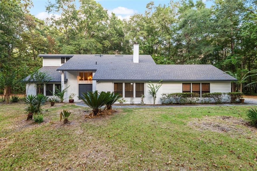 Beautiful 4BR/2.5BA Home on 1 Acre in NW Gainesville’s Sought-After Spring Forest Community! Discover this 2,571 sq. ft. two-story home tucked off scenic Millhopper Road, offering peaceful, nature-filled living just minutes from Hunters Crossing shops, Publix, restaurants, San Felasco Preserve trails, and Devil’s Millhopper State Park. Step inside to a bright foyer with a grand staircase, spacious formal living and dining rooms, and a large family room featuring a brick wood-burning fireplace and built-in cedar bookcases. The oversized kitchen offers abundant counter space, a breakfast nook overlooking the private backyard, and direct access to the screened porch — perfect for indoor-outdoor entertaining. A flexible office or guest suite with a half bath and an attached two-car garage provides excellent versatility. Upstairs, you’ll find four comfortable bedrooms, including a high-ceiling primary suite filled with natural light. Recent updates include fresh exterior paint (2023) and a new roof (2022) for added peace of mind. Set on a rare 1-acre wooded lot, this unique home — with great bones and a solid foundation — offers convenience, privacy, space, and tranquility, with views of deer and wildlife right from your windows, yet minutes away from all your daily needs. If this is the lifestyle you’ve been seeking, welcome home. Enjoy the charm, quiet, and convenience of Spring Forest — one of NW most desirable and rarely available neighborhoods but with low HOA!
