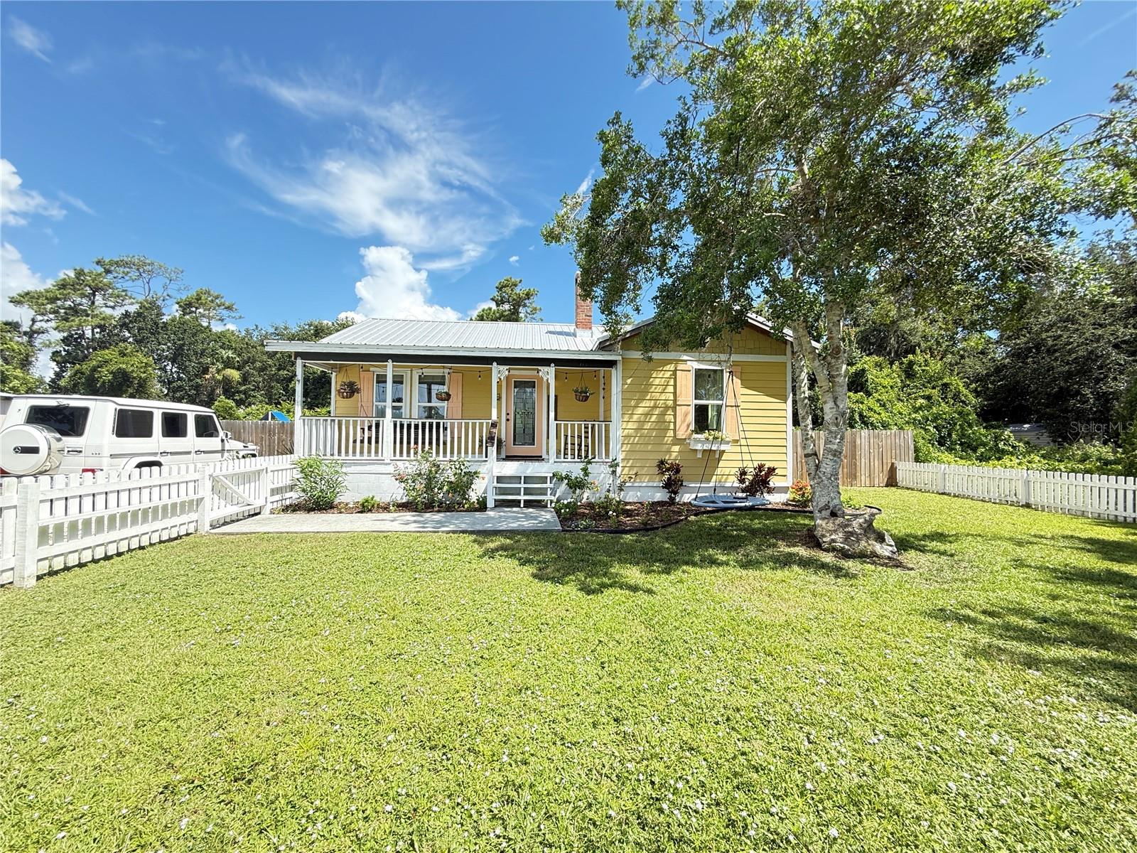 NSB Gem! Renovated cottage located on a double lot at the end of a quiet street. Updates include HVAC, plumbing, electrical systems, and Hardie board siding. The open floor plan features a cozy fireplace and abundant natural light. The gourmet kitchen is a chef's dream with solid stone countertops, charcoal and stainless refrigerator, natural gas stove and dishwasher. There is a center island with seating, tile kitchen back splash and a large sink in front of the window overlooking a peaceful wooded area. Additional highlights include real wood plank flooring, and a tankless gas water heater. Primary bedroom has decorative raised panelling on one wall. Bathroom features dual sinks. Huge fenced backyard with shed. Covered front porch and back deck with railing and gate. Enjoy and the convenience of being just 4-5 minutes away to the beach by golf cart or a few more minutes biking.