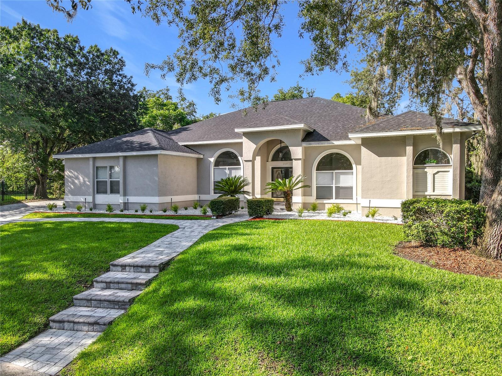 Welcome to a masterpiece of modern design and refined living in the prestigious Glen Eagle community of Tuscawilla. Built in 2023, this architectural re-imagining tucked away in a quiet cul-de-sac features 5-bedrooms and 3.5-baths and epitomizes luxury, sophistication, and thoughtful homage at every turn while encapsulating the modern family space. Bathed in natural light, the home showcases a brilliant interplay between design and illumination. Stunning porcelain tile with a marble-like finish flows seamlessly throughout the home, complementing the extravagant yet refined lighting fixtures that accentuate the home’s elevated aesthetic. The heart of the home is a show-stopping central kitchen, complete with sleek floor-to-ceiling white cabinetry accented with warm woodgrain niches and integrated LED lighting. A grand, white granite island offers an inviting centerpiece ideal for entertaining, culinary artistry, and family interconnectivity. The open-concept layout is enhanced by soaring ceilings and expansive windows, creating palatial living spaces that exude elegance and warmth. A substantial formal dining room is perfect for lavish dinner parties, while the stylish formal living room provides a serene space for conversation. The inviting family room, anchored by a sleek electric fireplace, flows effortlessly into the kitchen and living area—all overlooking the resort-style pool deck. The primary suite is a private sanctuary—expansive and serene, featuring a sun-kissed sitting area and direct pool access via a sliding glass door. The spa-inspired en suite bath is a statement in luxury, boasting a floating dual vanity with LED smart mirrors, an oversized walk-in shower, a single-piece designer toilet, and a custom walk-in closet designed for the discerning homeowner. Every secondary bedroom offers generous proportions and comfort, while the home’s layout has been meticulously planned for both privacy and flow. Step outside to a covered pool oasis with a pavered deck designed for year-round enjoyment. Whether hosting guests or relaxing in solitude, this outdoor haven is the perfect complement to the modern interior. Glen Eagle lies in the heart of the Tuscawilla community which features miles of walking trails, golf cart friendly roads, multiple parks and greenspaces including tennis and pickleball courts, as well as the Tuscawilla Country Club. A rare opportunity to own a truly bespoke residence in one of Central Florida’s most sought-after communities.