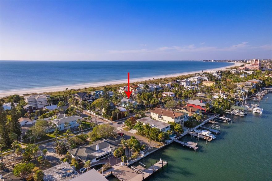 Walk the pristine shores of Pass-a-Grille, every day from your front door.   Come be captivated by the charm of this beach residence.  The top main floor, designed penthouse style, offers two bedrooms, two baths a gorgeous white kitchen with gray accents, a bright and vibrant living space with an open concept for dining.  The first floor is a full suite with another two bedrooms, two baths, it's own living room, laundry and a kitchen (minus the range).  This high-end property showcases meticulous architectural design and craftsmanship throughout.  Inside, you'll discover spacious and light-filled living areas adorned with high ceilings, large windows, and exquisite finishes. The open concept layouts seamlessly integrate the living, dining, and kitchen spaces, creating a perfect setting for entertaining If combined living is needed, no problem, if privacy or even a rental is desired, that's just as possible.  For multi-generational dwelling, this home is perfect.  Older relatives would not need to do a flight of stairs to be home.  The main living area of the home is an open floor plan.  The deep lot and back yard (Pass-a-Grille Way side) is the perfect space for adding a pool, outdoor kitchen or both.  The upstairs offers a serene balcony with gas grill and seating where you can relax and soak in the breathtaking views of the surrounding area or just enjoy the coastal breeze. Immediately inside the french doors off this balcony is a wet bar with a 54 bottle wine chiller -- perfect for cozy fresh air get togethers. All four bedrooms are en-suite allowing for a perfect guest experience. The primary bath is a spa retreat to be envied. Aside from the two car garage there is also a parking pad for extra cars - another rare and envious feature. Situated on the prestigious Pass-a-Grille peninsula, this home offers an unparalleled lifestyle. Residents will enjoy easy access to pristine white-sand beaches, vibrant local restaurants, boutique shops, and a variety of recreational activities. Whether it's a leisurely sunset stroll along the shore or indulging in the vibrant coastal culture, the possibilities are endless.