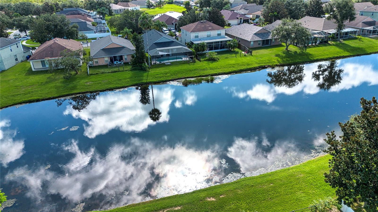 One or more photo(s) has been virtually staged. The original owners are selling their well maintained and updated home with a great pond view. The home includes hurricane high impact windows and patio sliding door 2018, roof 2018, gutters, fenced backyard, fresh paint inside including garage, updated kitchen cabinets, under counter lighting, back splash with granite countertop, and stainless-steel appliances. The kitchen includes a laundry closet and large pantry. The kitchen has a view out to pond and very large patio. The patio has an electric shade screen. The primary bedroom is separate from other bedrooms for privacy. The area has been updated with new flooring, shelving in walk in closet, and has a totally updated bathroom with tile shower and dual sinks. The tax record lists home as four bedrooms, however, one is currently being used as an office and could be used as a flex room. The separate hallway leads to bedrooms, second bathroom with tub/shower and garage. The two-car garage has extra insulation in ceiling as recommended by electric company to save energy. This home is move in ready and waiting for you.