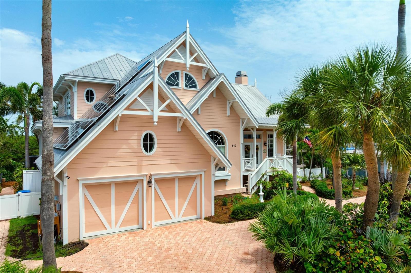 Home! Home is where families gather for Sunday dinners and special occasions. Home! From the moment you step inside you will think “it feels like home”. Discover the iconic Emily-Anne Smith designed family residence nestled in the heart of Holmes Beach on Anna Maria Island. This one-of-a-kind coastal retreat is as unforgettable as its signature pink exterior and its place as a beloved local landmark that captures the spirit of island living. Offering nearly 2800 square feet of thoughtfully designed living space, this home also boasts an additional 1000 square feet under roof, including an expansive screened back porch overlooking sailboat water and a mangrove preserve. Soaring cathedral ceilings, rich architectural details, and an inviting Craftsman style brick fireplace flanked by custom built in bookcases create a warm, welcoming ambiance. Walls of windows flood the living spaces with natural light and showcase stunning views of the lush Florida landscape. The cooks kitchen features a 6-burner gas WOLF range with a pasta faucet, a SUB-ZERO refrigerator, a BOSCH dishwasher, granite counters and a vegetable sink. The upstairs loft area was designed as a space where families can have fun. It includes a pool table and TV room, a bedroom with ensuite bathroom plus a large playroom and “secret” treehouse. Situated on a prime canal lot with direct access through Bimini Bay to Tampa Bay, makes this a true boaters paradise.